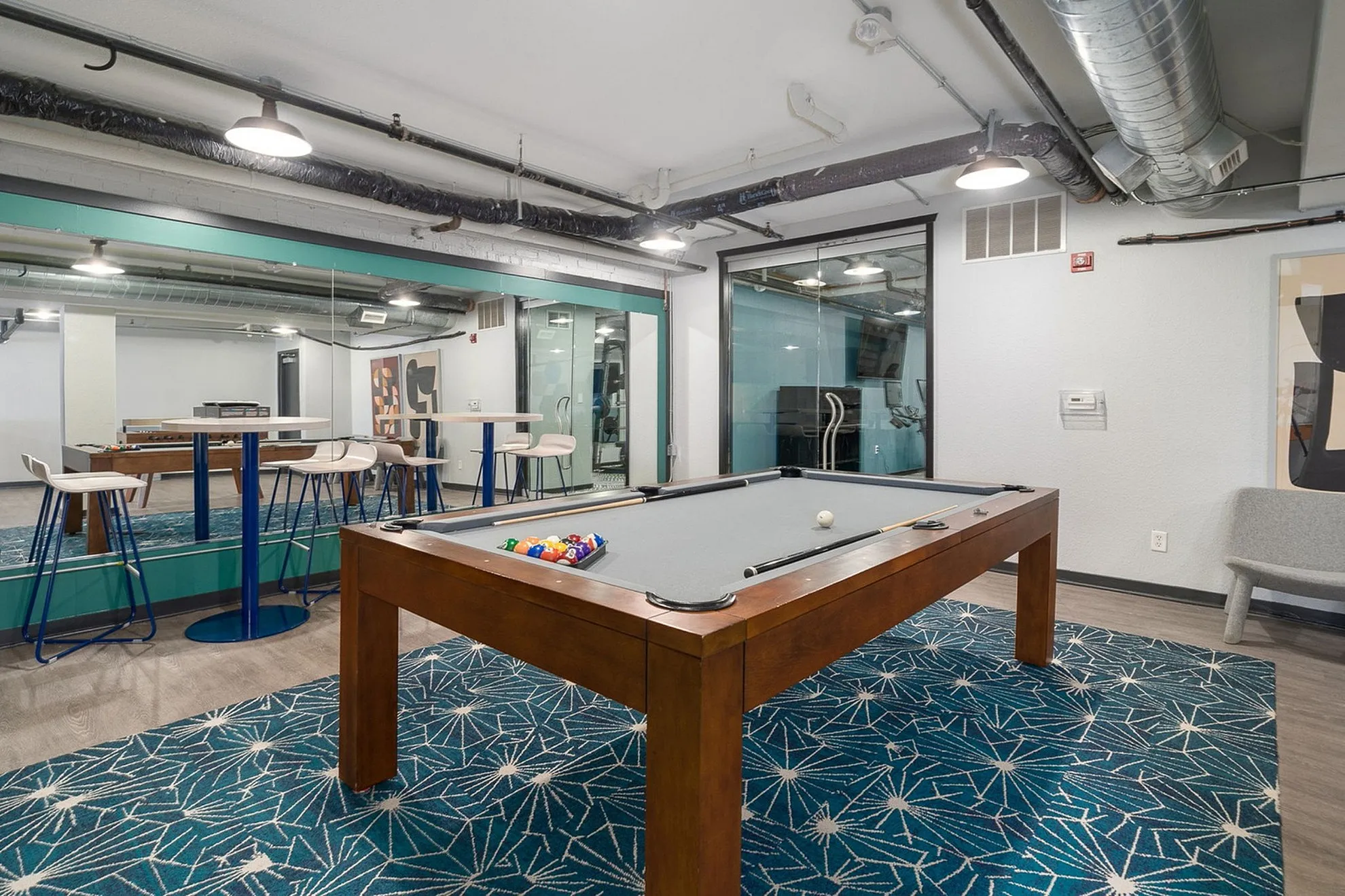 Modern recreational area with a stylish pool table, chic seating, and vibrant decor, perfect for entertainment and relaxation.