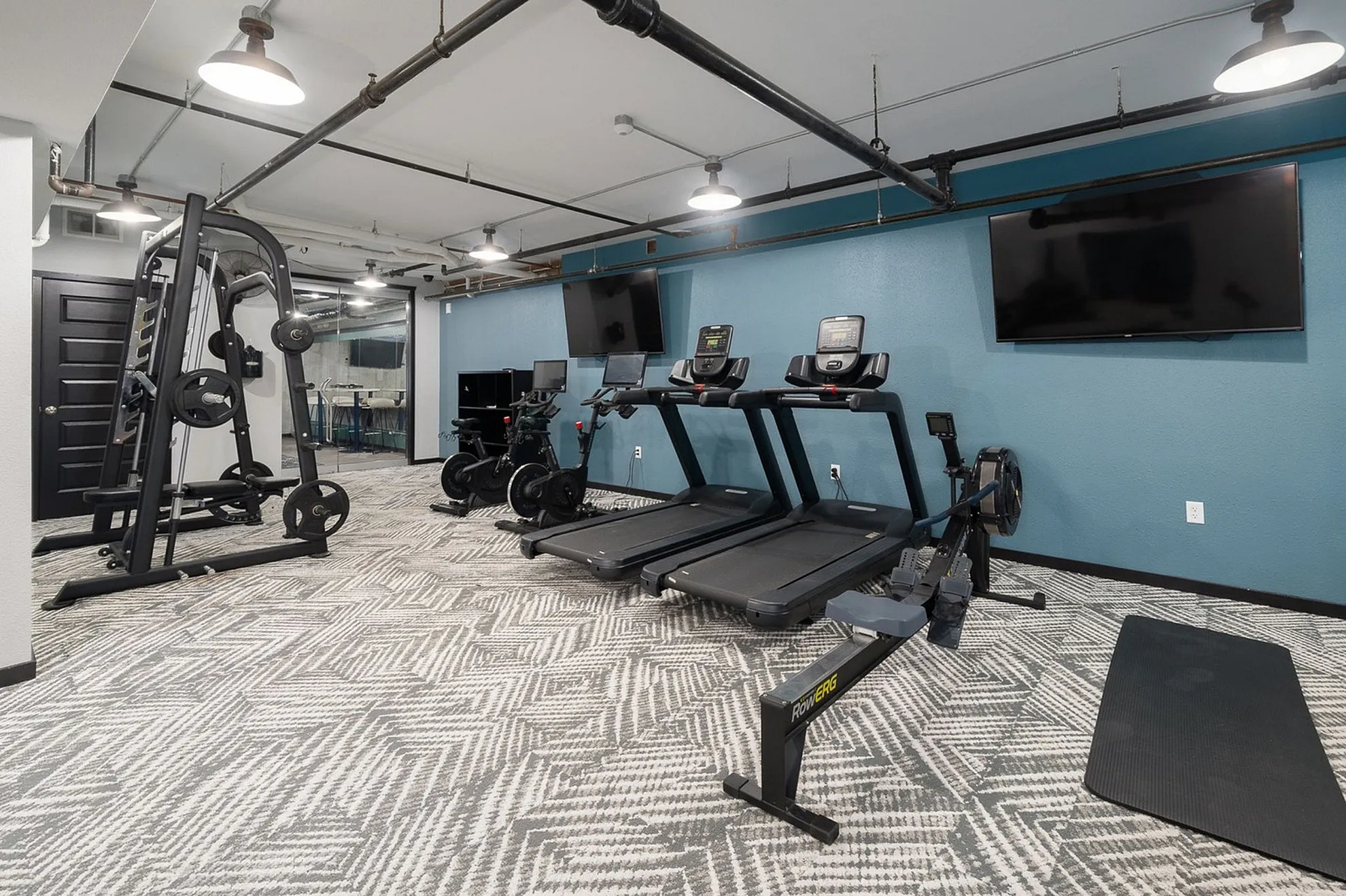 Modern gym facility featuring state-of-the-art equipment including treadmills, exercise bikes, and weight machines, designed for a premium workout experience.