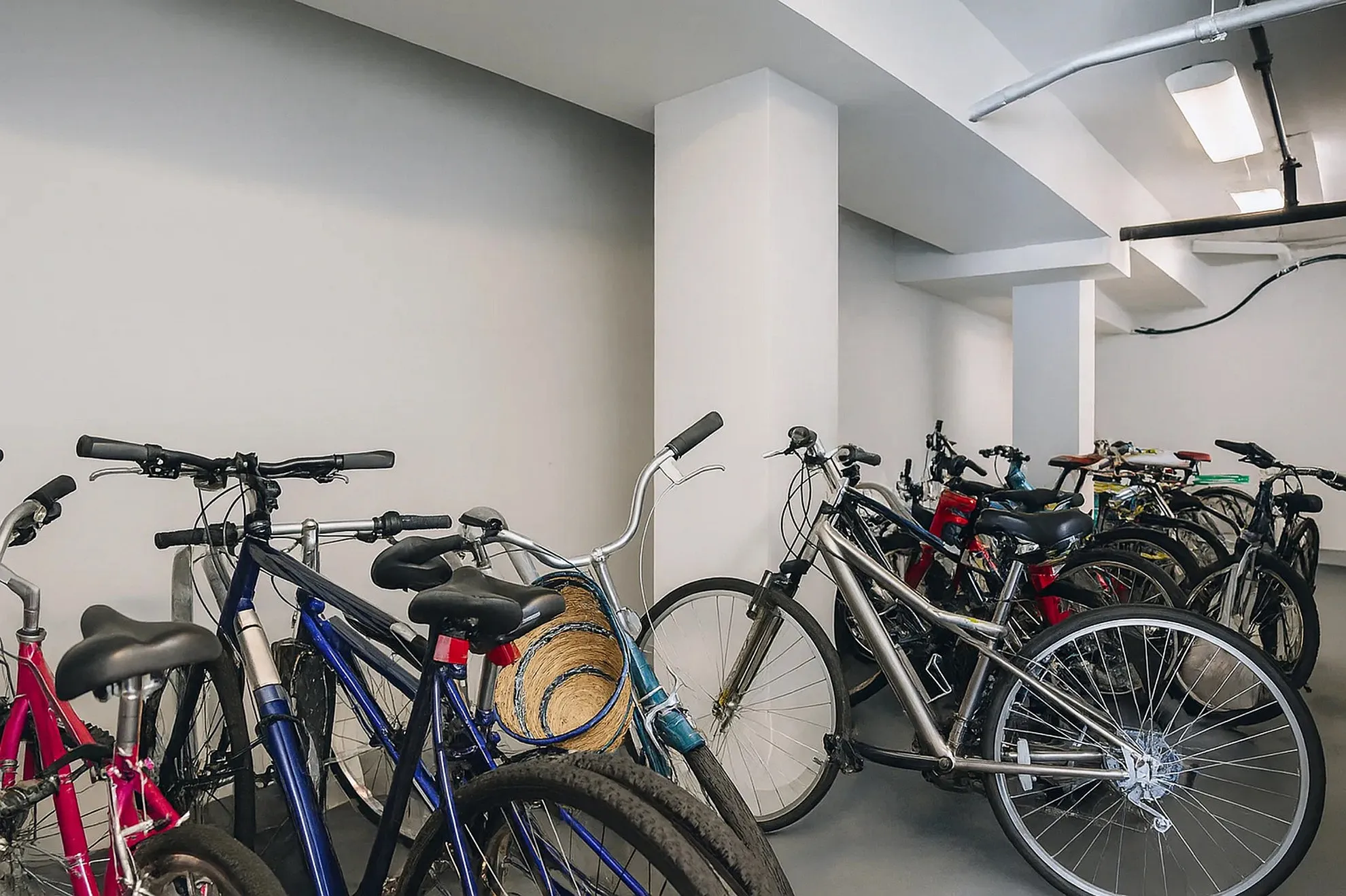 Secure and spacious indoor bicycle storage area with multiple bikes neatly organized, ideal for active residents.