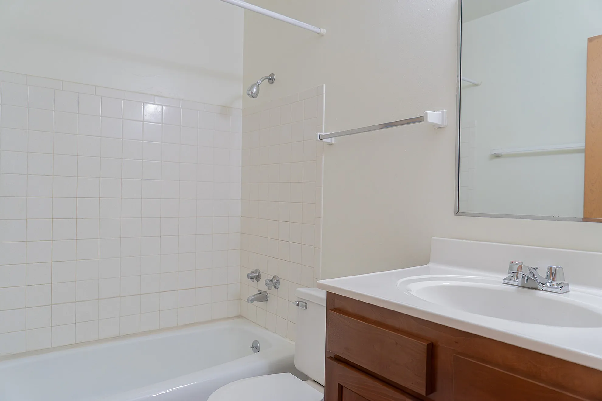 Bright and modern bathroom with a sleek mirror, pristine bathtub, and elegant vanity in a tranquil setting.