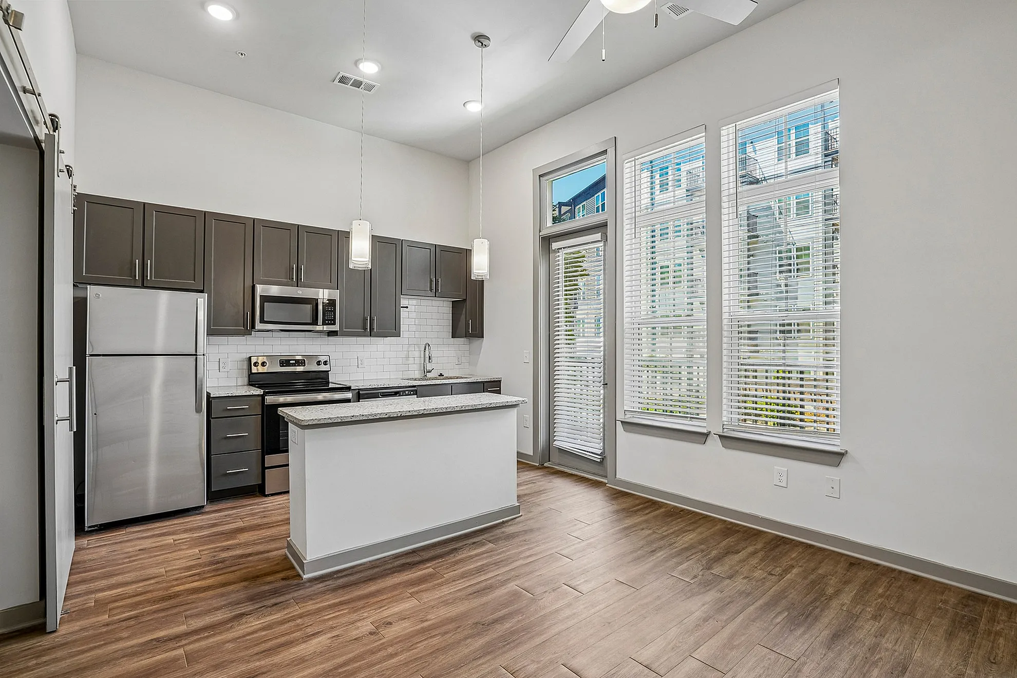 Modern kitchen with sleek cabinetry, stainless steel appliances, and natural light pouring through large windows.