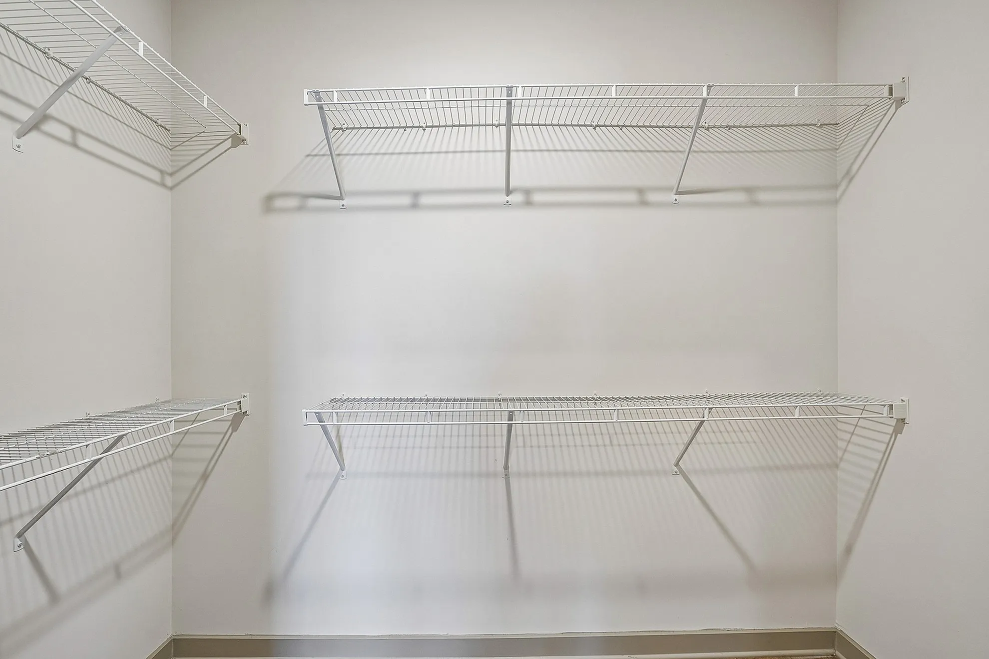 Spacious walk-in closet with sleek wire shelving offering ample storage space.