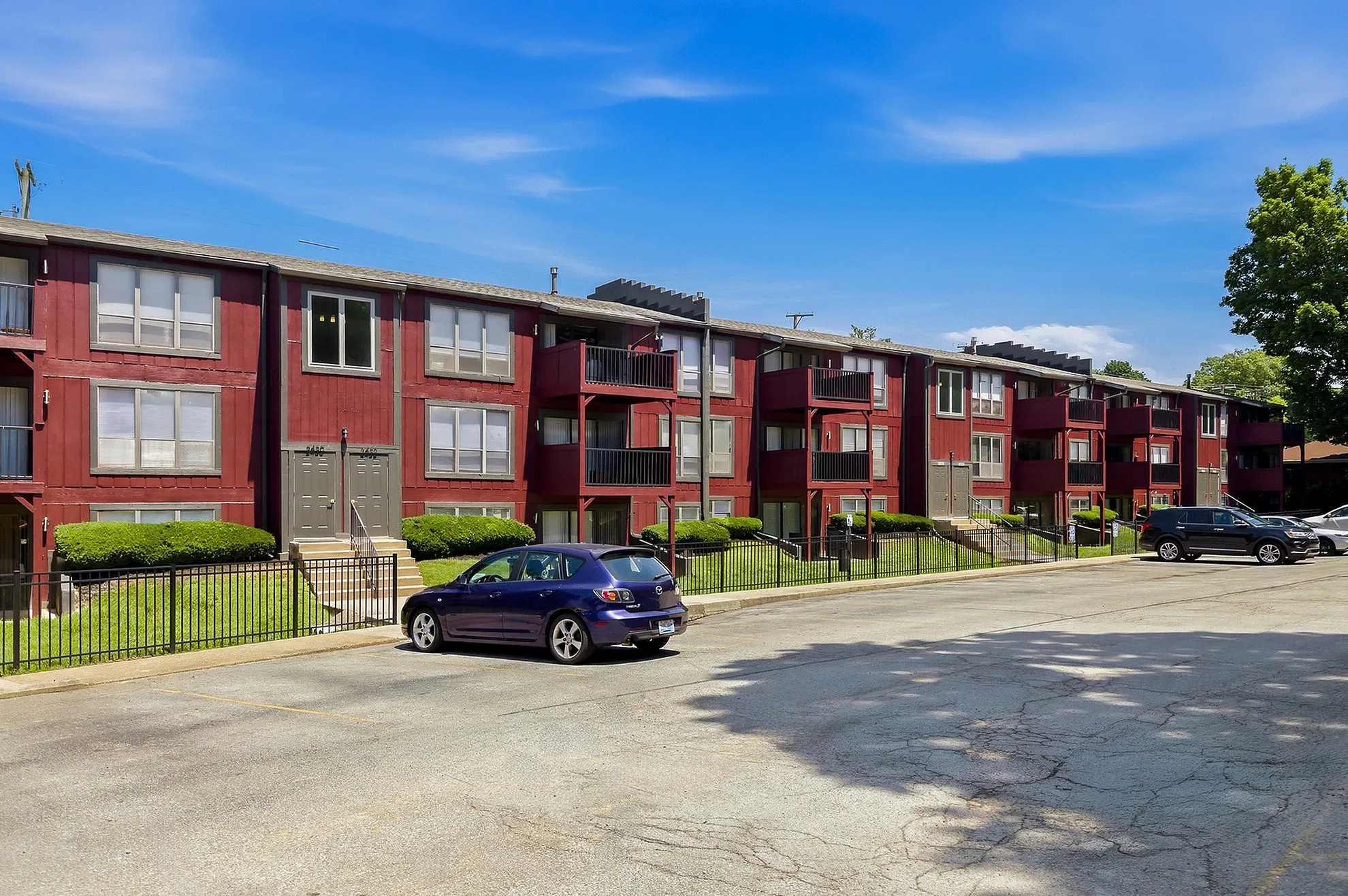 Charming red-brick apartment complex with balconies and lush greenery, offering comfortable and stylish living.