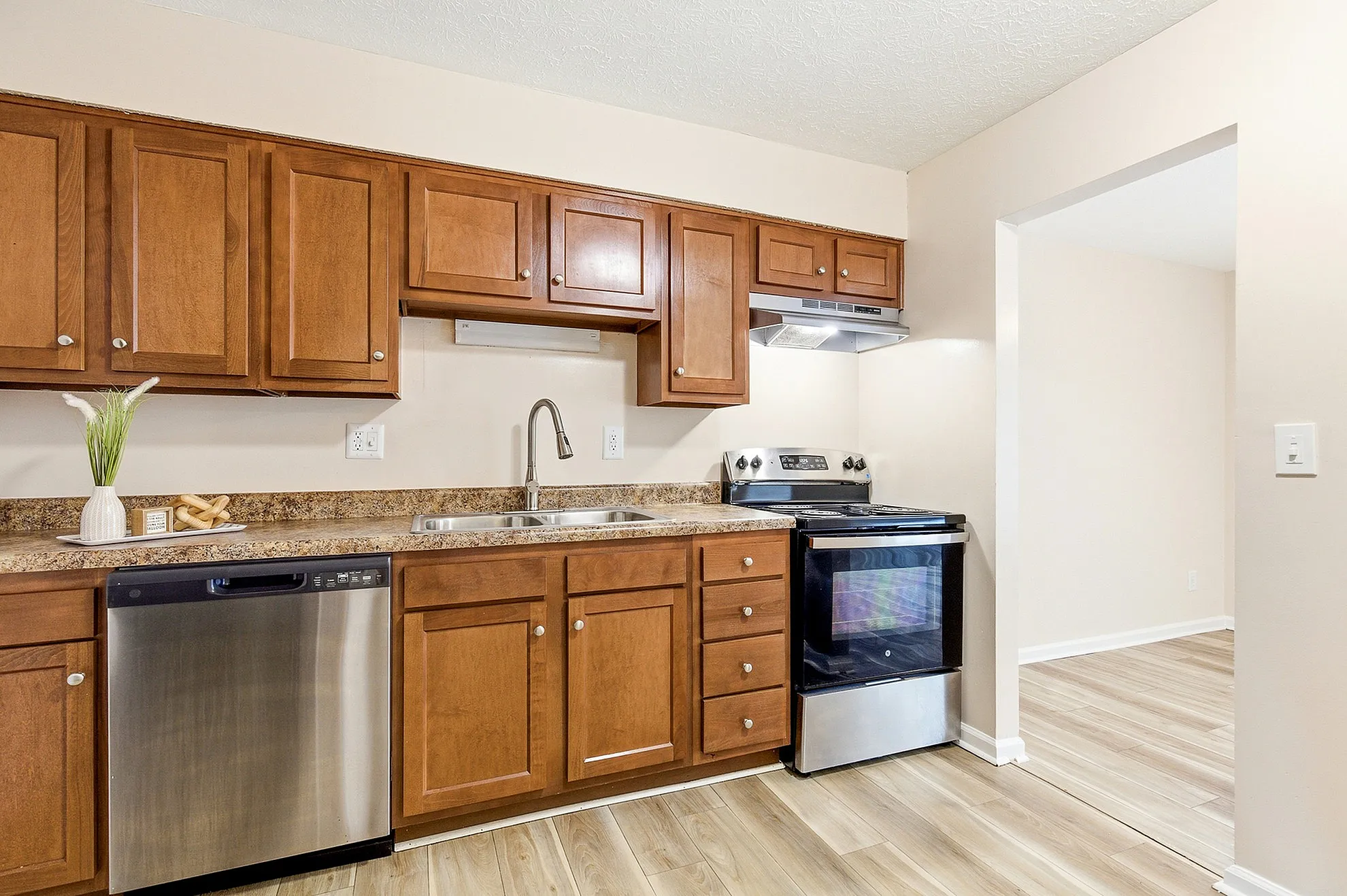 Modern kitchen with sleek stainless steel appliances, elegant wooden cabinets, and polished countertops, offering a warm and inviting space.