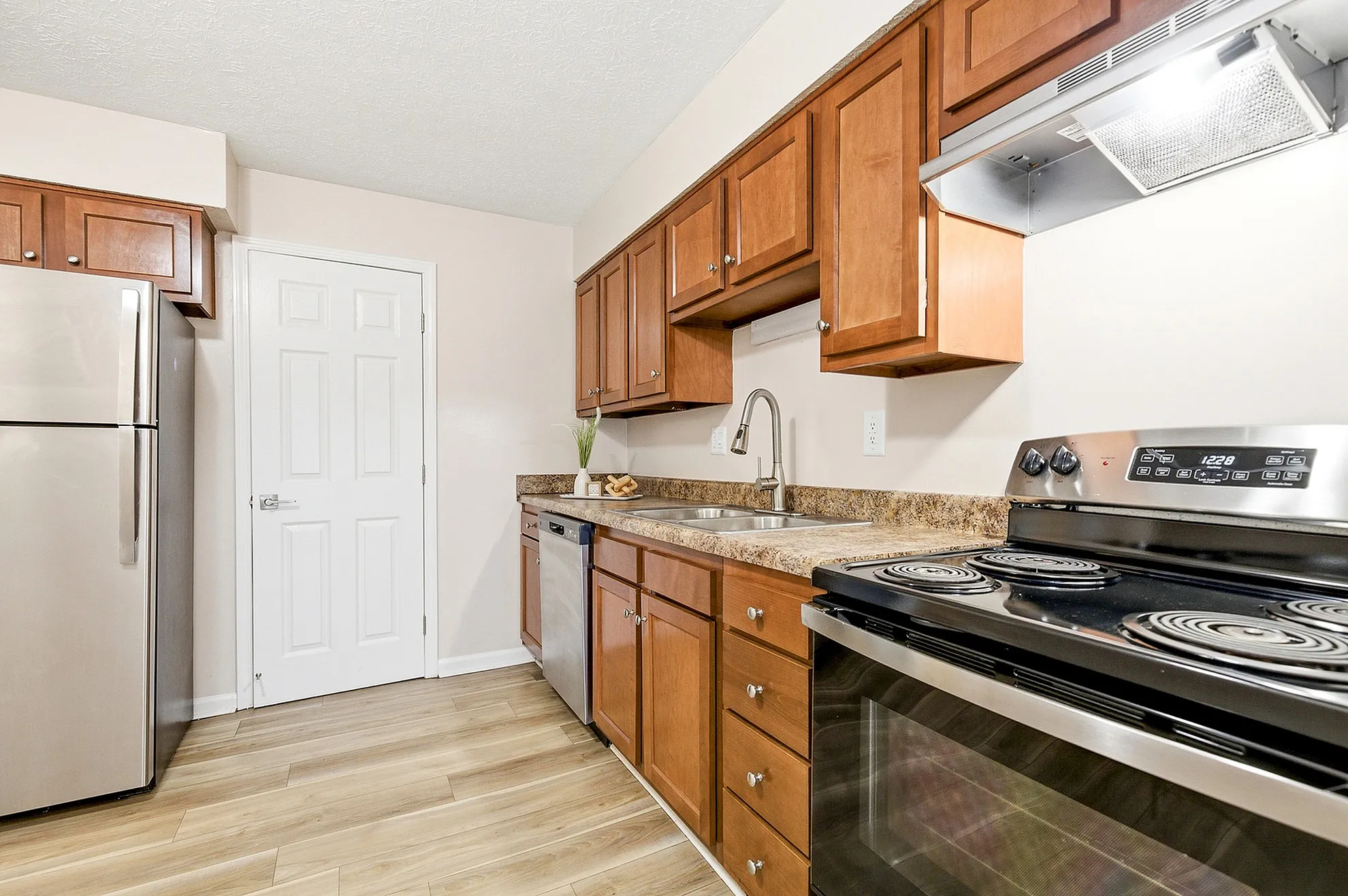 Modern kitchen with sleek stainless steel appliances, elegant wood cabinetry, and stylish granite countertops.