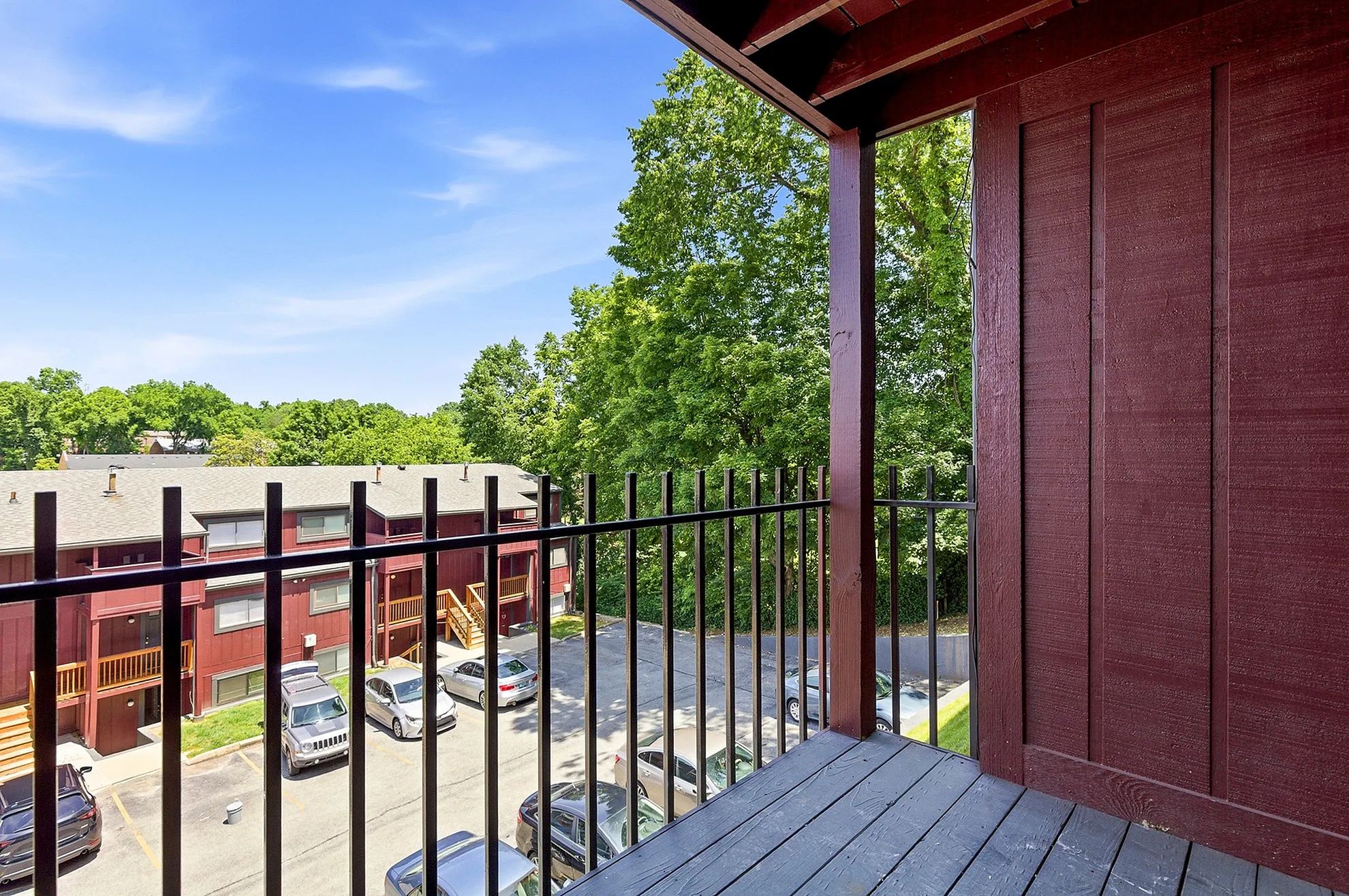 Charming balcony view overlooking lush greenery and residential buildings, perfect for relaxation.