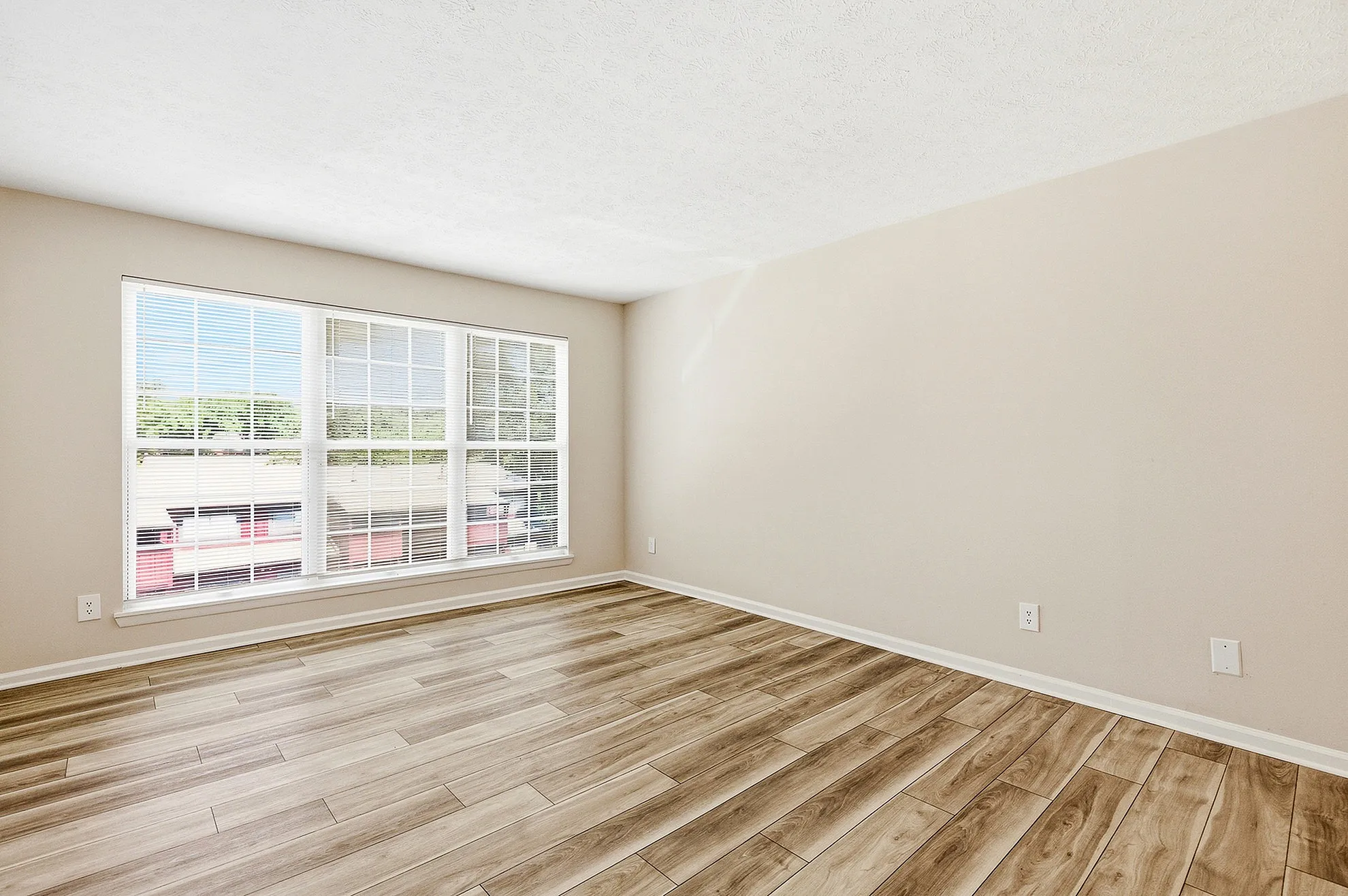 Bright and airy room with elegant hardwood flooring and large windows offering ample natural light.