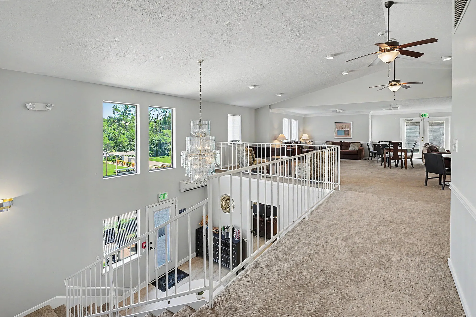 Elegant open-plan apartment with lush views, featuring a spacious living area, modern chandelier, and inviting dining space.