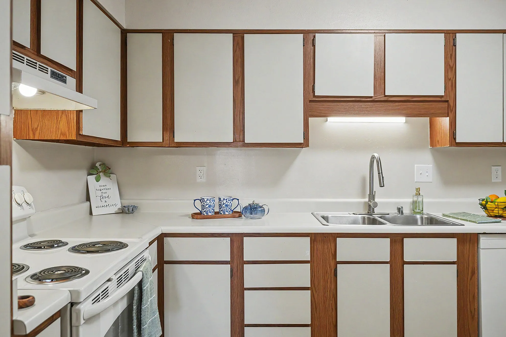 Charming kitchen with retro-style cabinets, modern stainless steel sink, and cozy countertop decor.