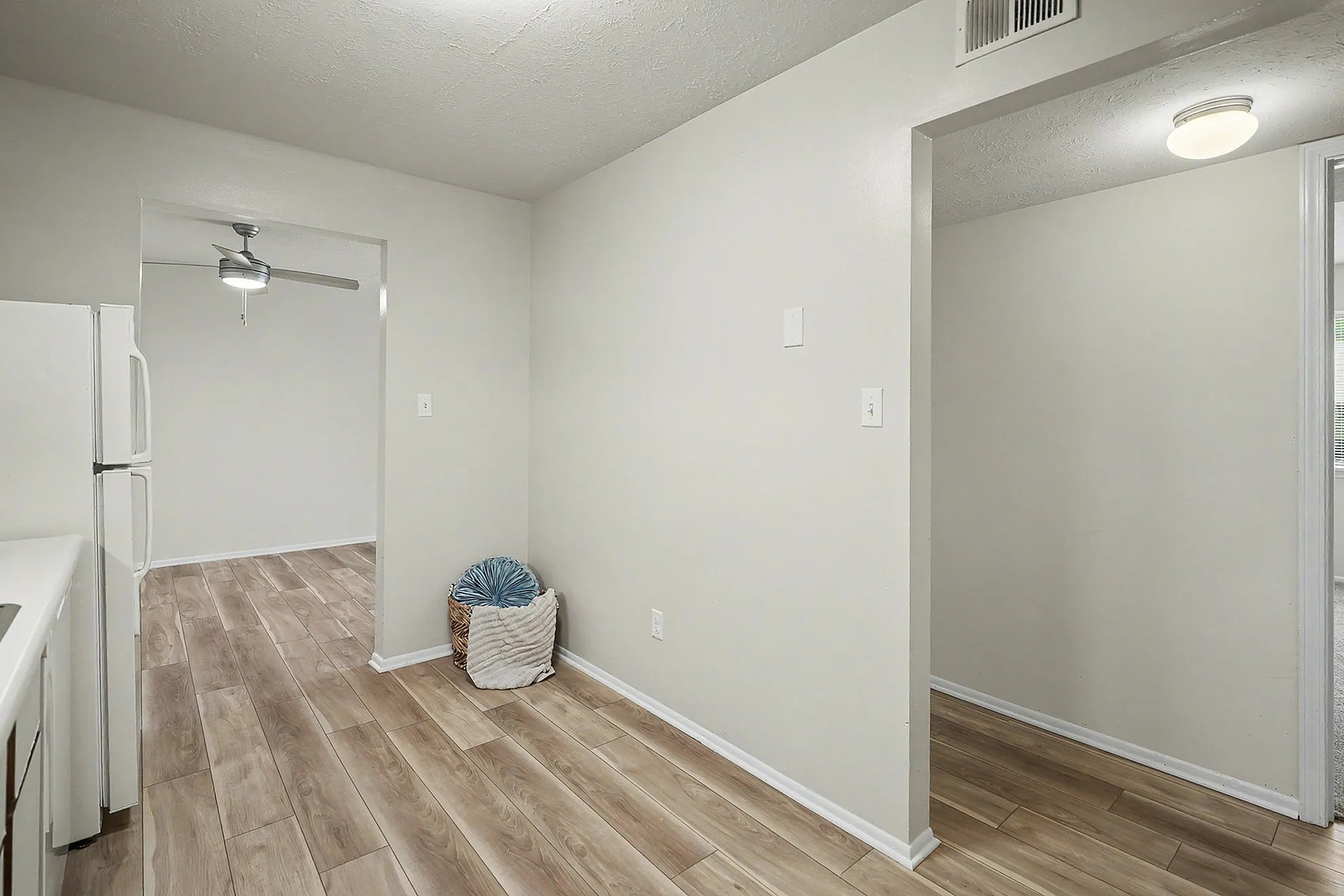 Inviting apartment space featuring sleek wooden floors, modern lighting, and a cozy nook ideal for personalization.