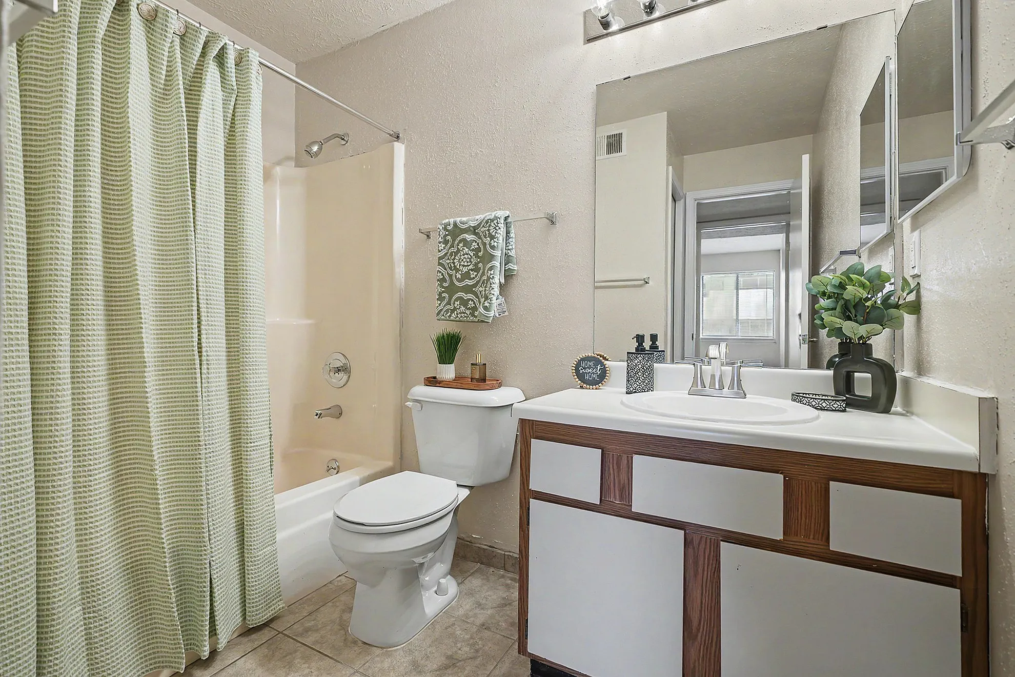 Inviting bathroom featuring stylish vanity, elegant lighting, and refreshing decor.