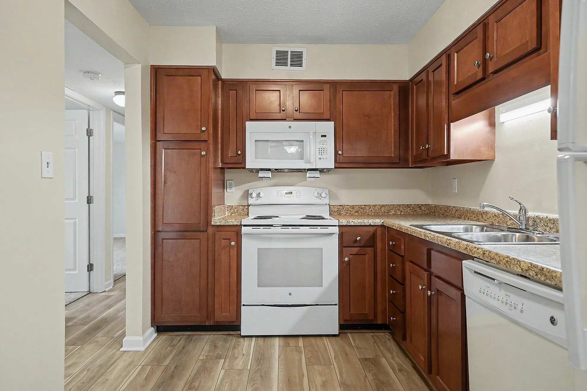 Elegant kitchen with rich wood cabinetry, modern appliances, and sleek countertops, perfect for culinary enthusiasts.