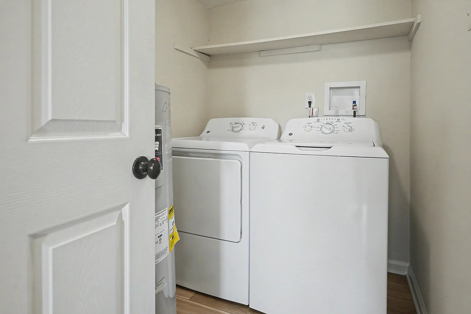 Modern in-unit laundry room with efficient washer and dryer, complemented by sleek storage solutions.