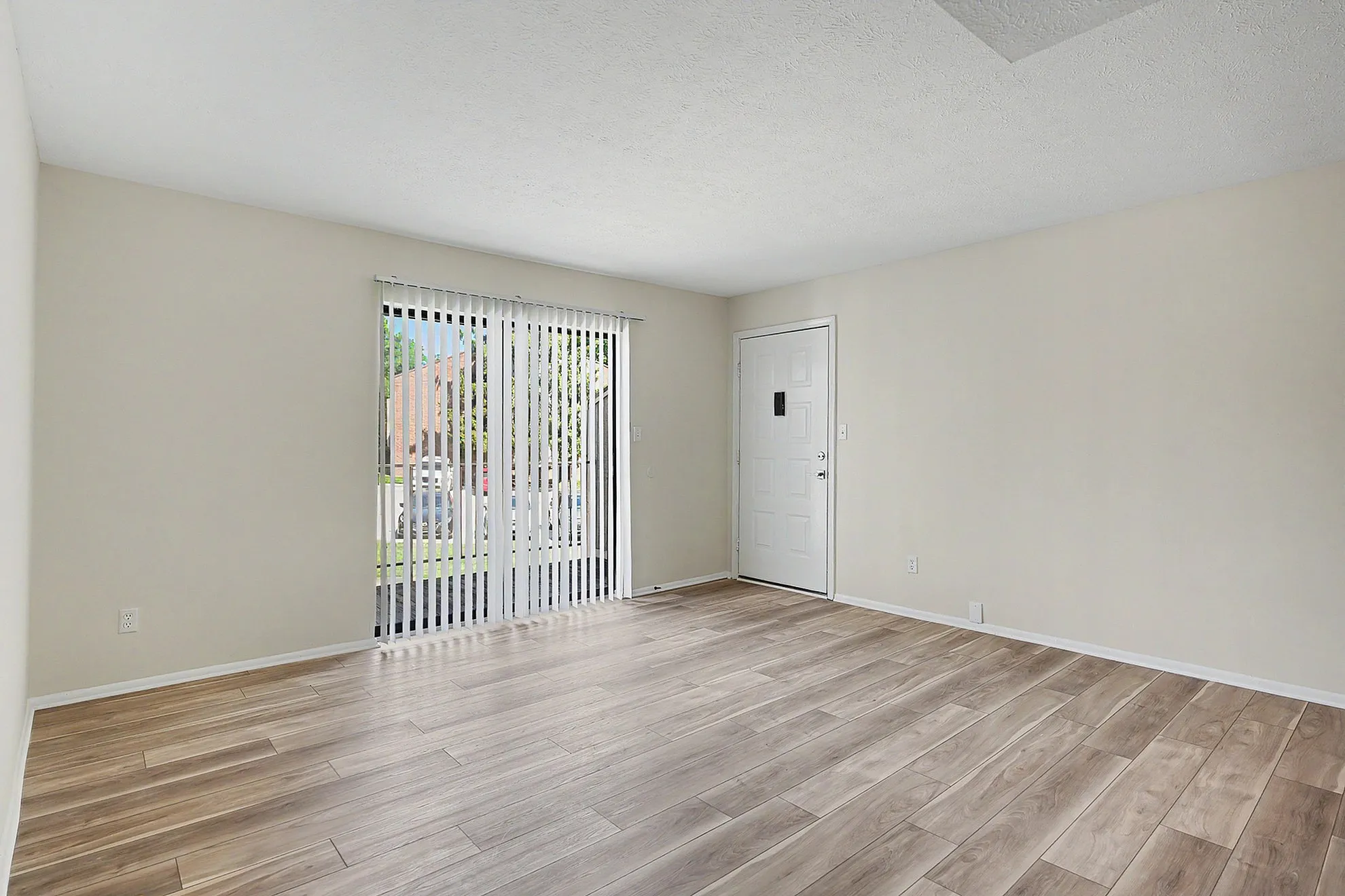 Bright and airy living room with elegant wood flooring and large sliding doors inviting natural light.