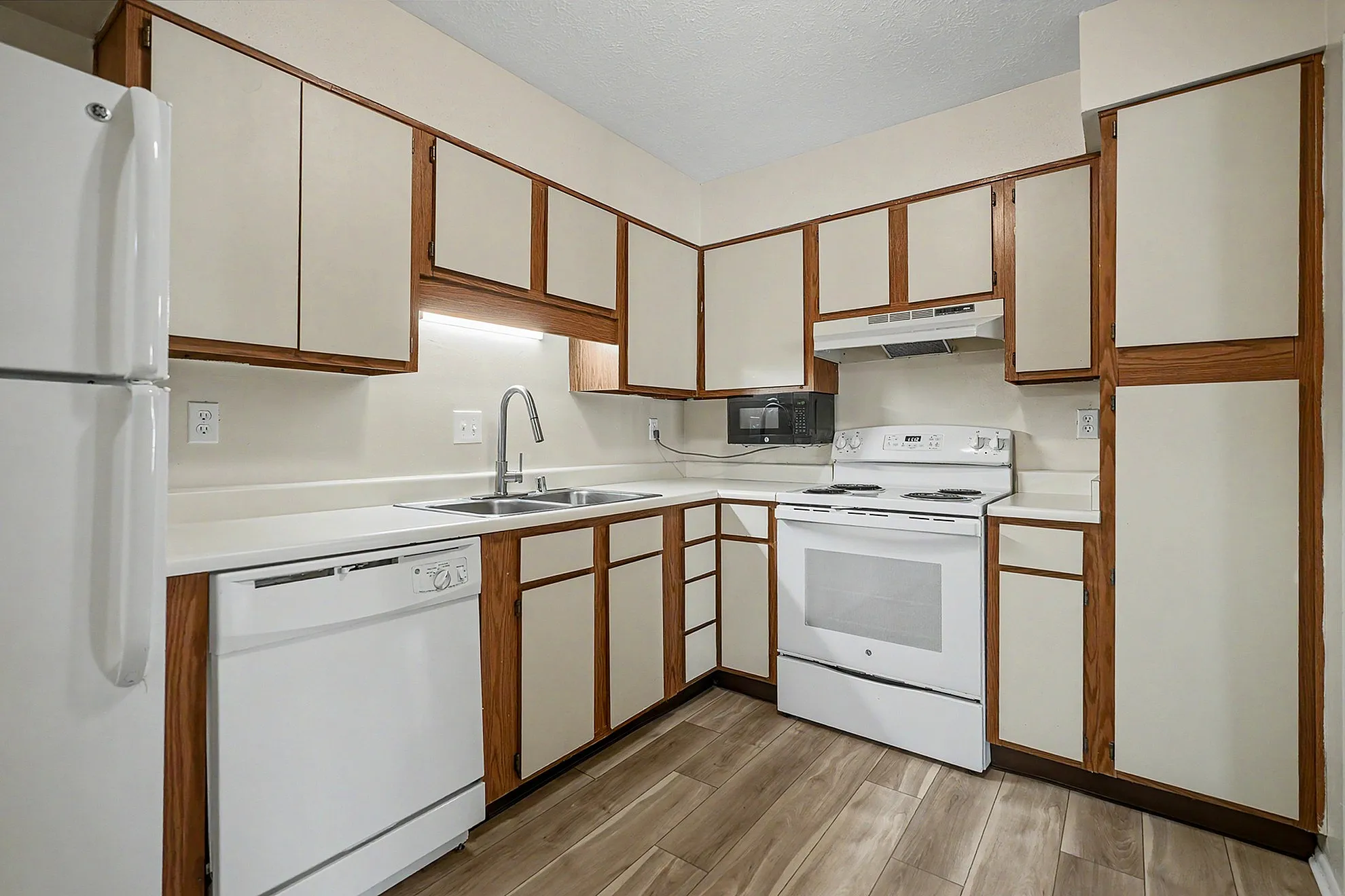 Charming kitchen featuring modern appliances, sleek cabinetry, and stylish wood flooring.