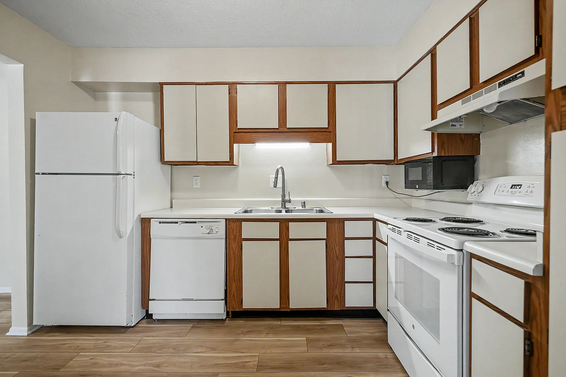 Inviting kitchen with modern appliances, ample cabinetry, and wooden flooring, perfect for culinary adventures.