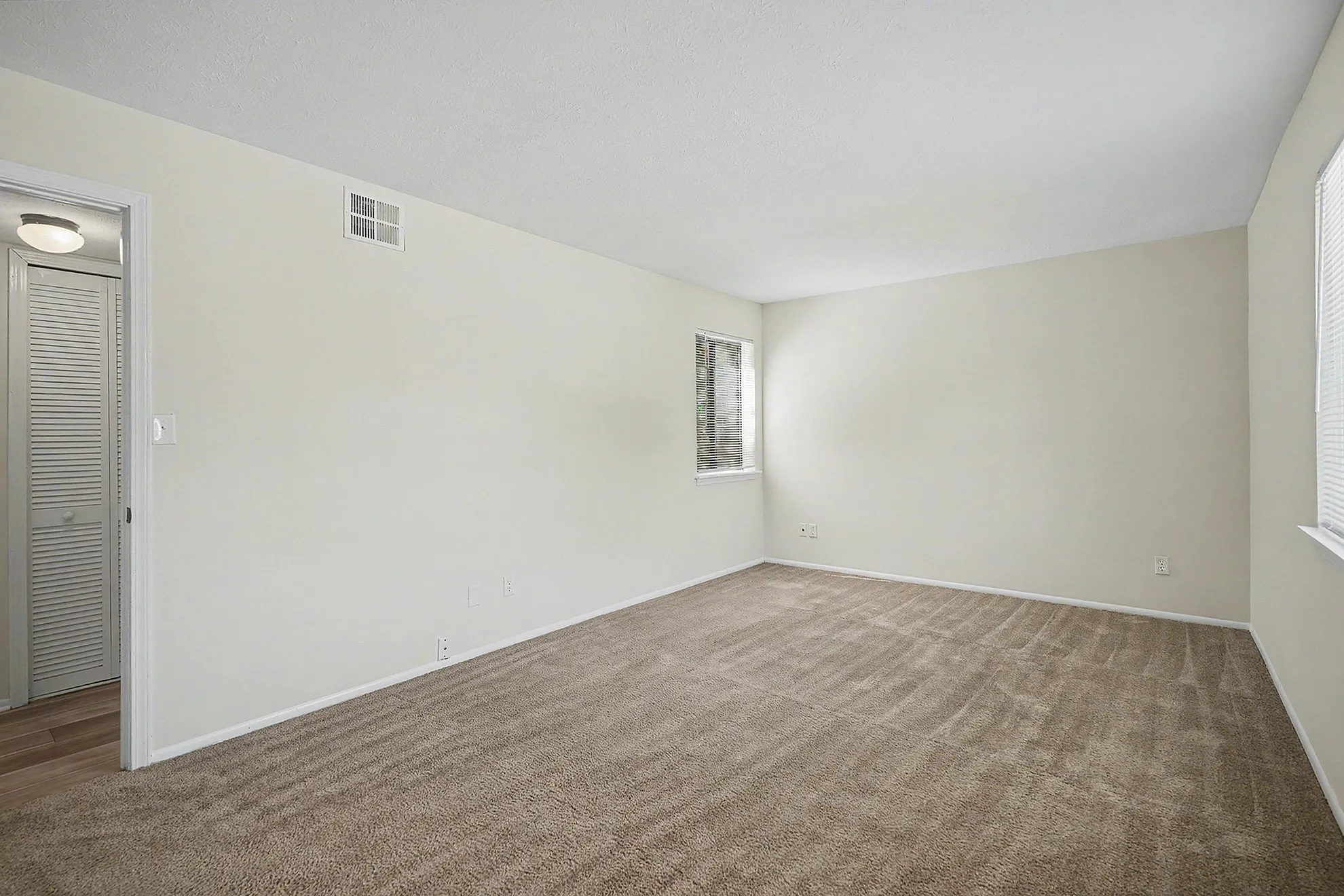 Bright and spacious room with soft carpet flooring, perfect for creating a cozy living or bedroom area.