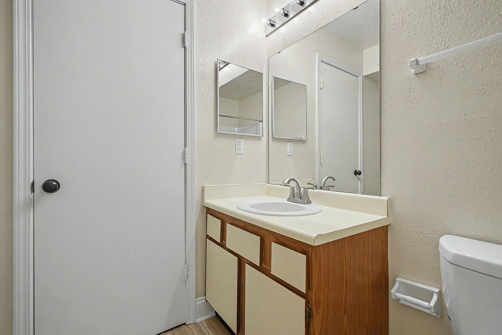 Bright and inviting bathroom featuring a sleek vanity with ample storage and a large mirror, perfect for a modern home.