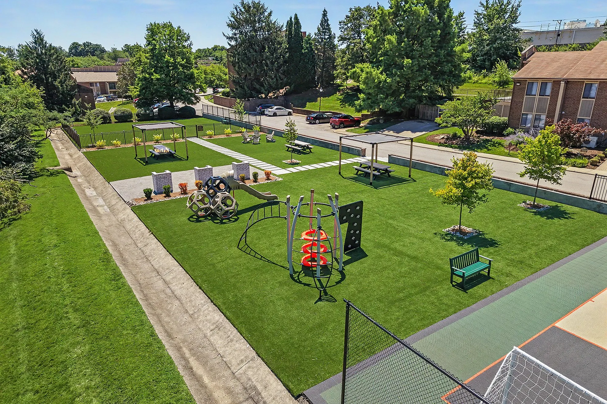 Vibrant community park featuring lush green spaces, a modern playground, picnic tables, and scenic walking paths.