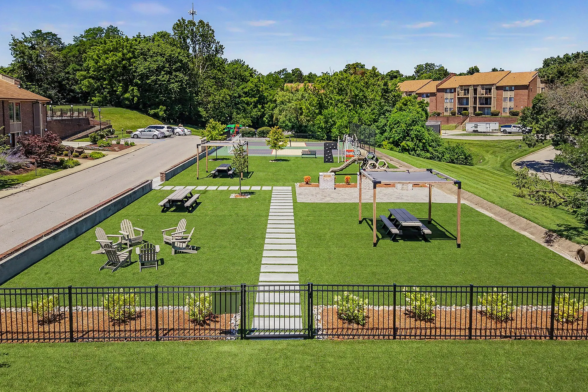 Inviting outdoor space with lush green lawn, picnic areas, and cozy seating, perfect for relaxation and gatherings.