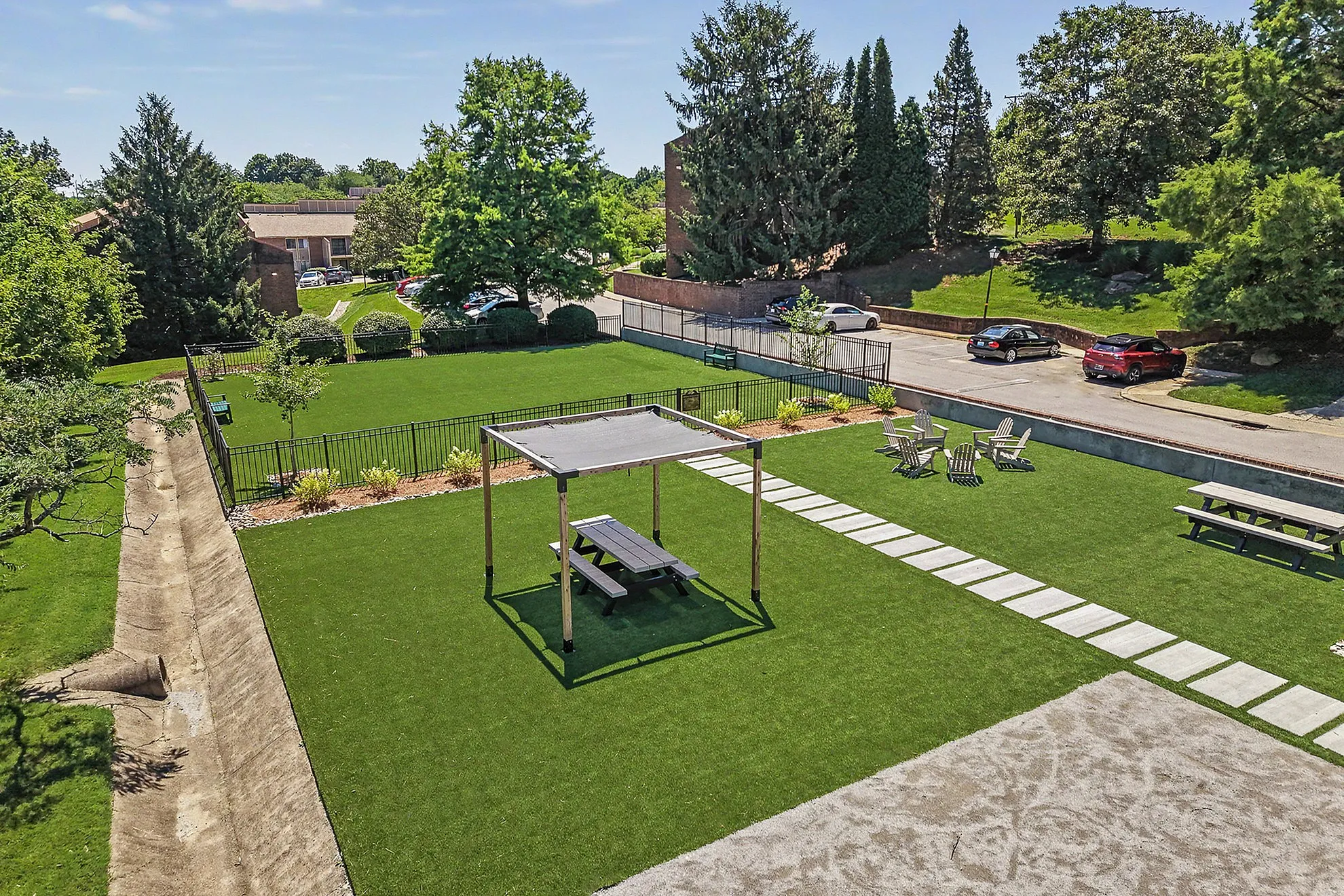 Inviting outdoor oasis featuring lush green gardens, a shaded picnic area, and cozy seating for relaxation.