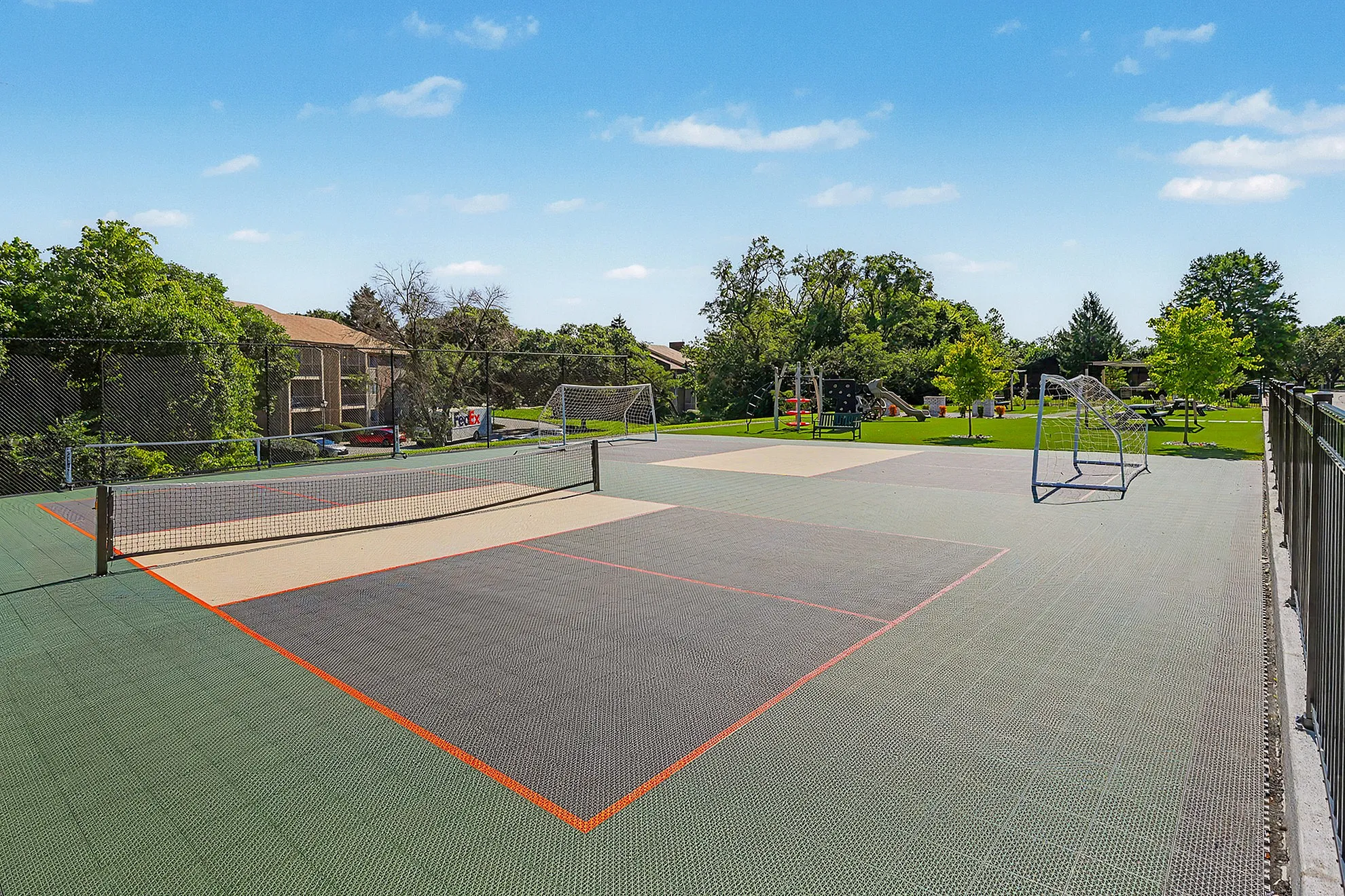 Inviting outdoor sports court with tennis and soccer amenities, surrounded by lush greenery and cozy seating areas.