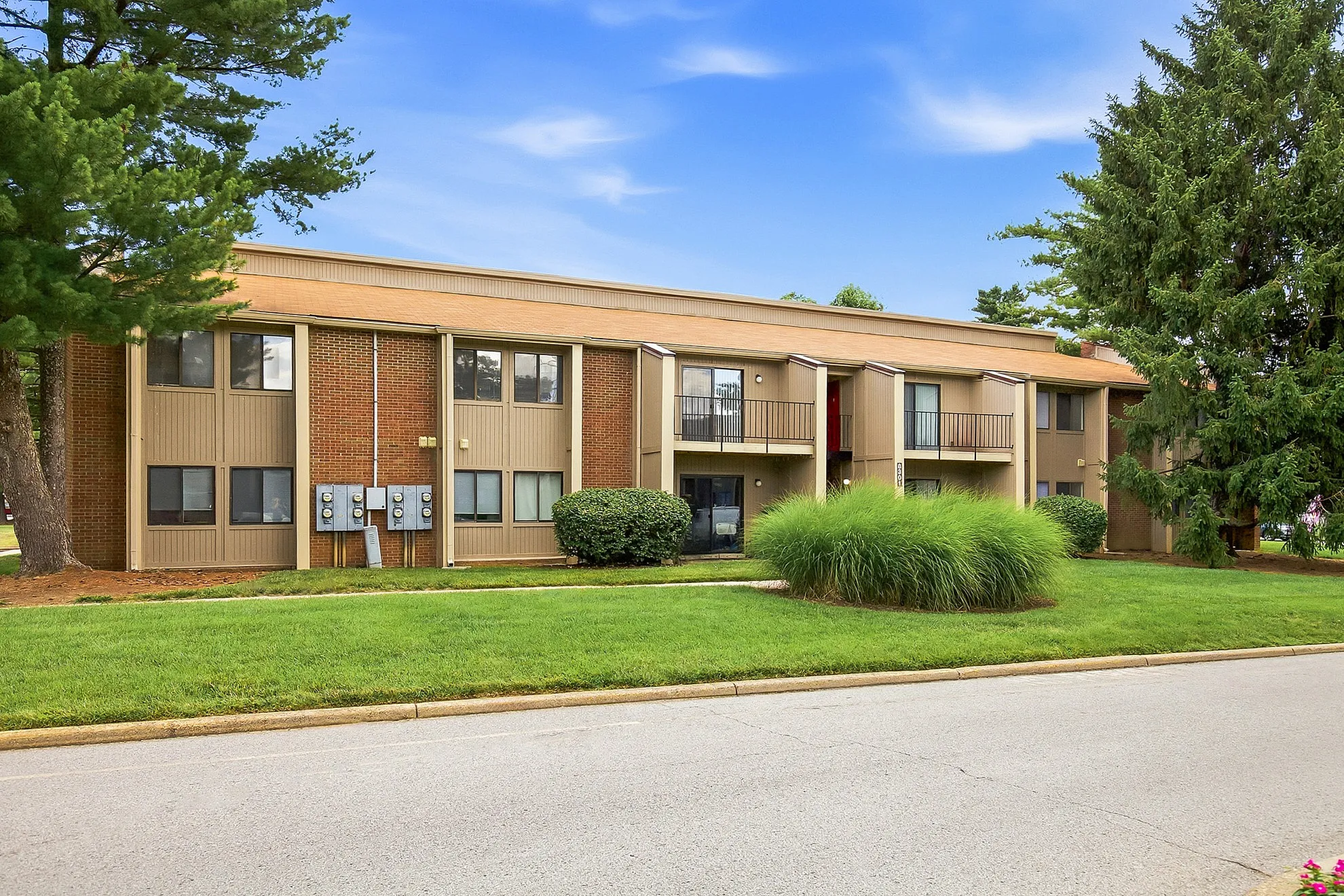Inviting apartment complex with modern design, lush green landscaping, and serene surroundings.