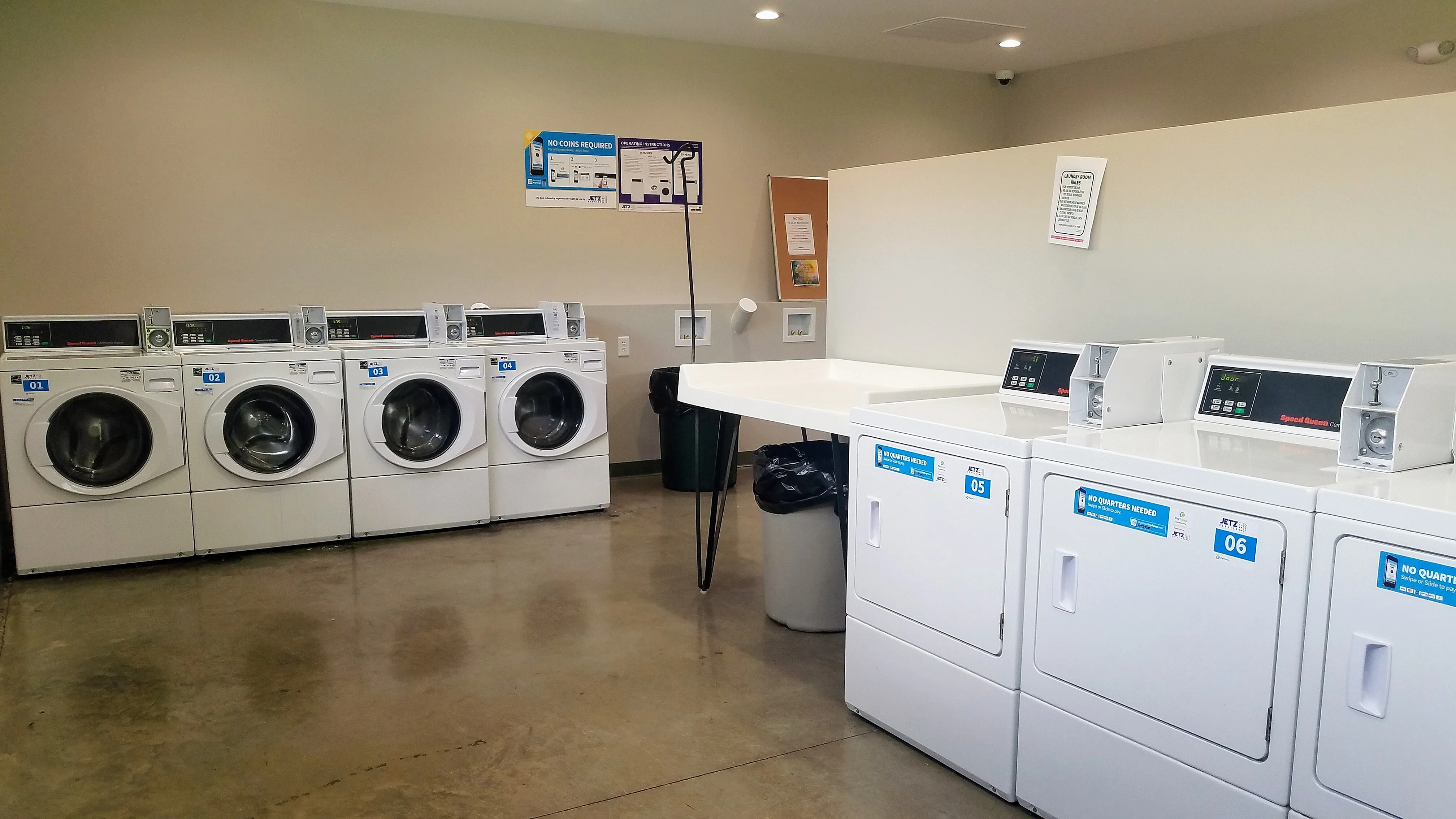 Modern apartment laundry room featuring efficient washers and dryers in a clean and well-organized setting.
