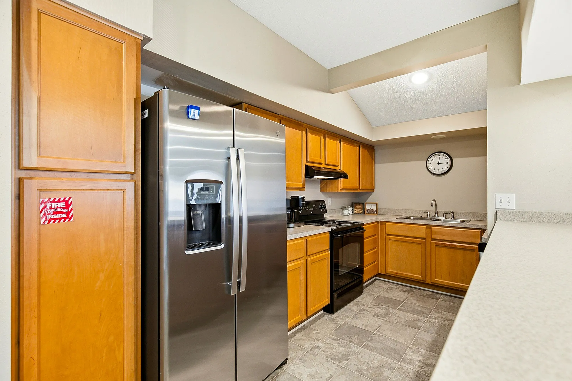 Modern kitchen with stainless steel appliances, warm wooden cabinetry, and spacious countertops.