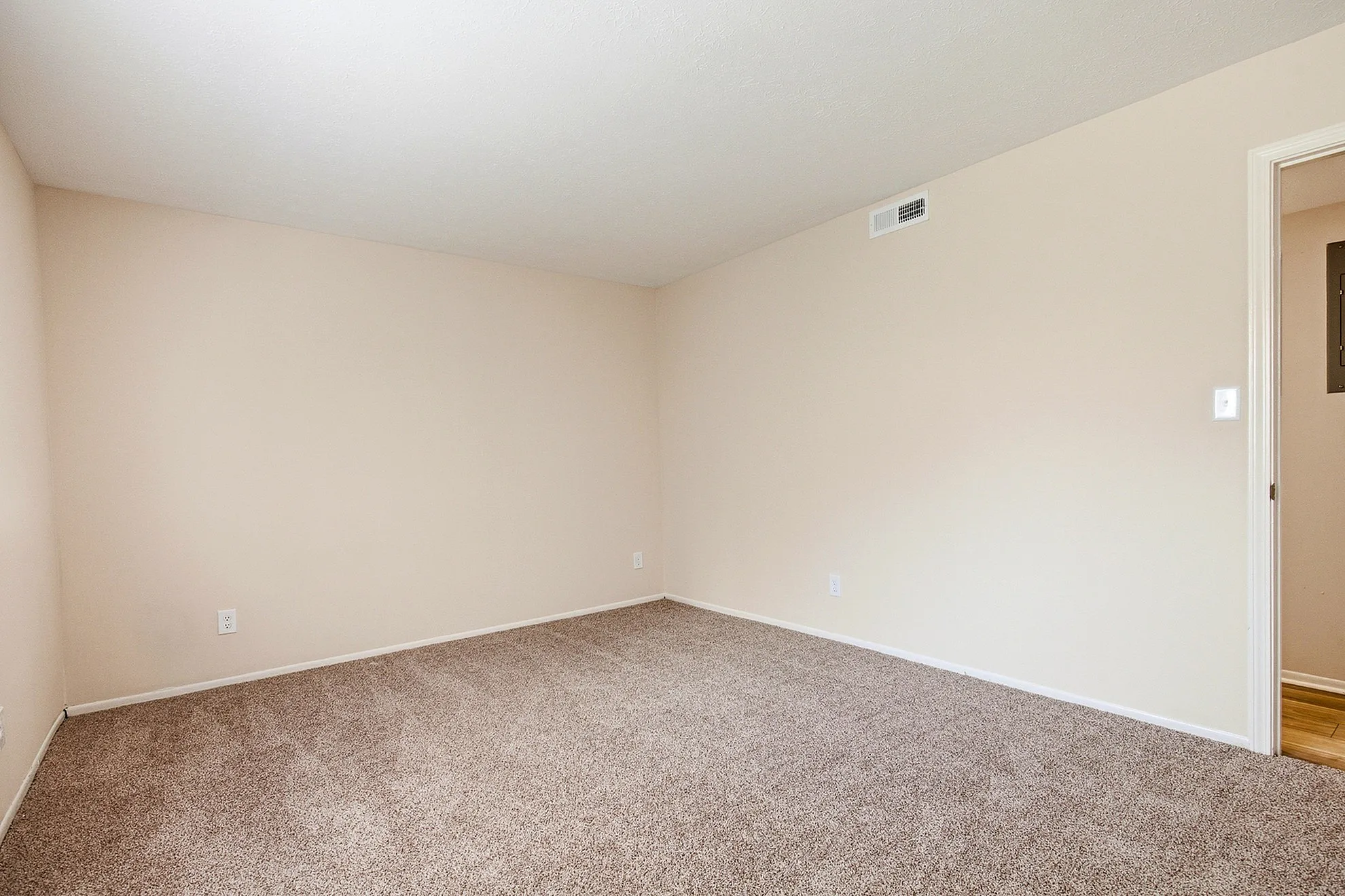 Spacious and inviting empty room with plush carpet and neutral walls, perfect for creating your personalized living space.