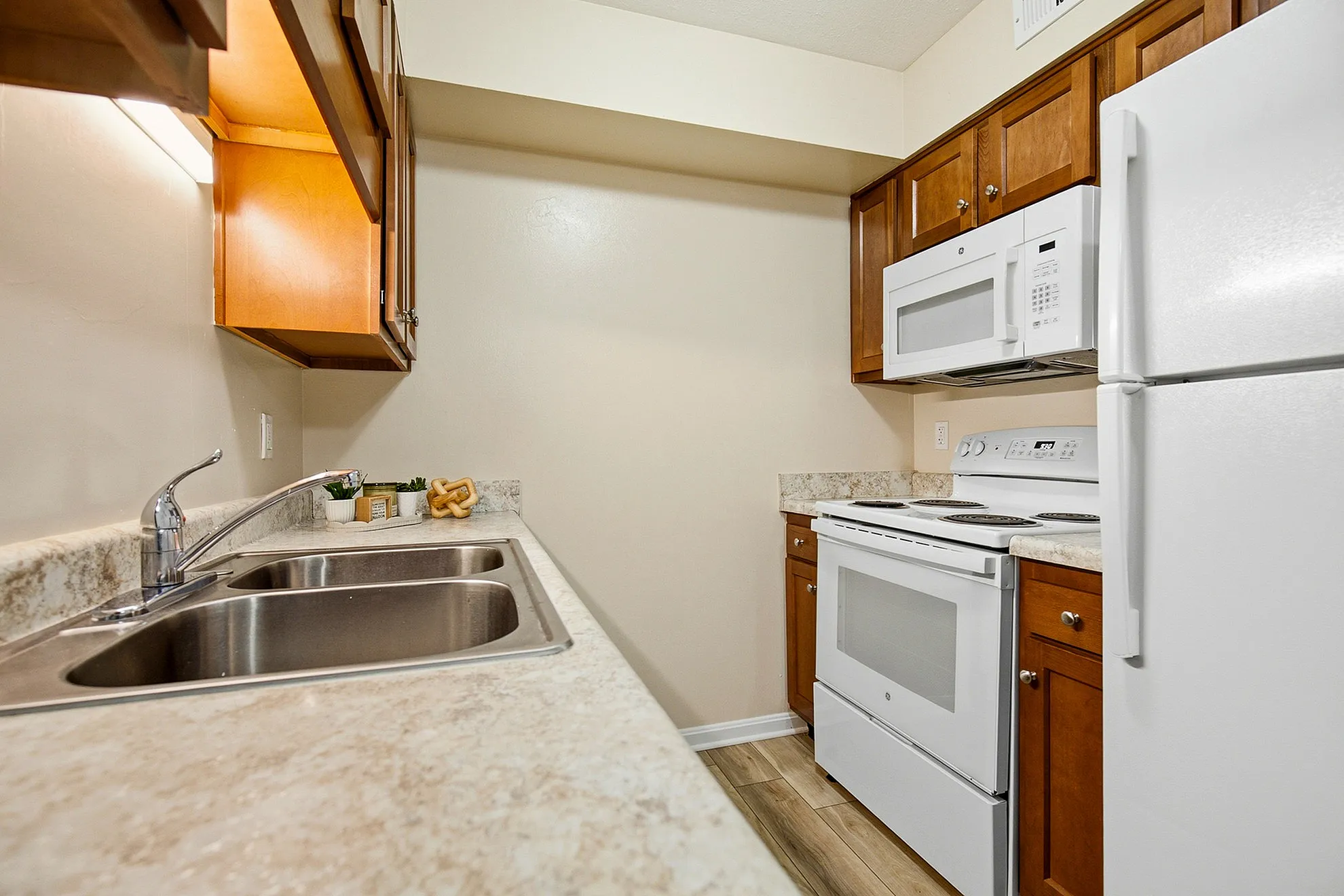 Charming kitchen with modern appliances, elegant countertops, and warm wood cabinetry, perfect for culinary creativity.