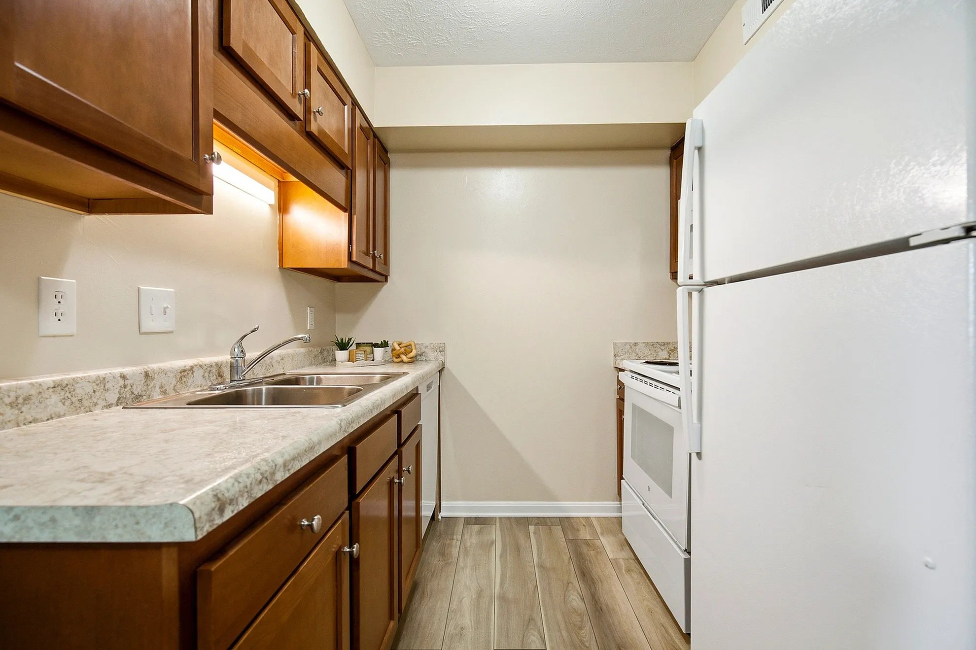 Chic apartment kitchen with modern appliances, elegant wooden cabinetry, and stylish countertops, perfect for culinary creativity.