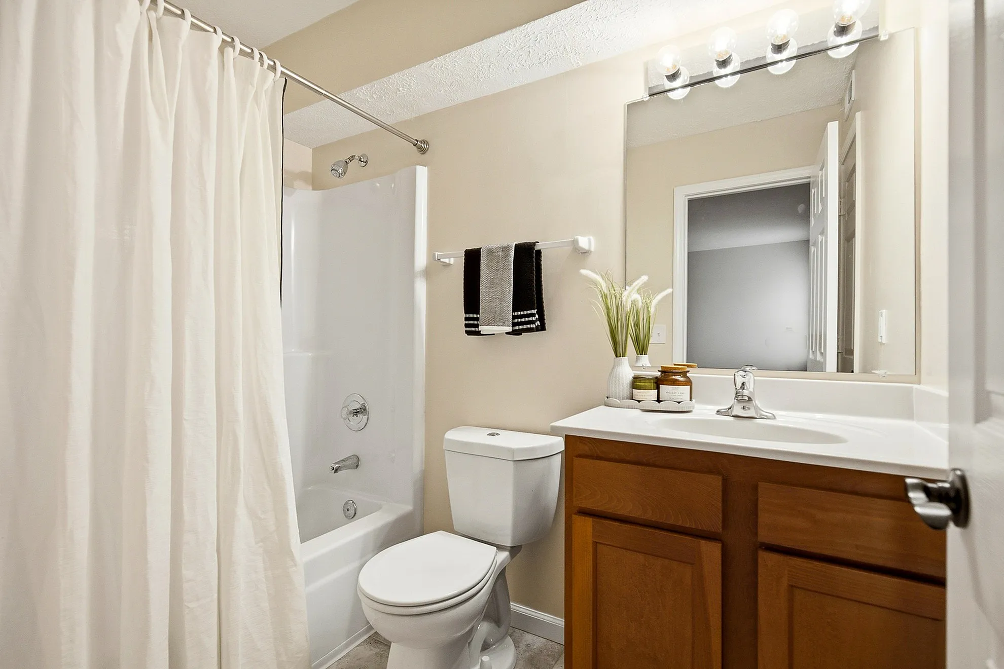 Elegant bathroom featuring a modern vanity, polished fixtures, and cozy lighting, offering a serene space for relaxation.
