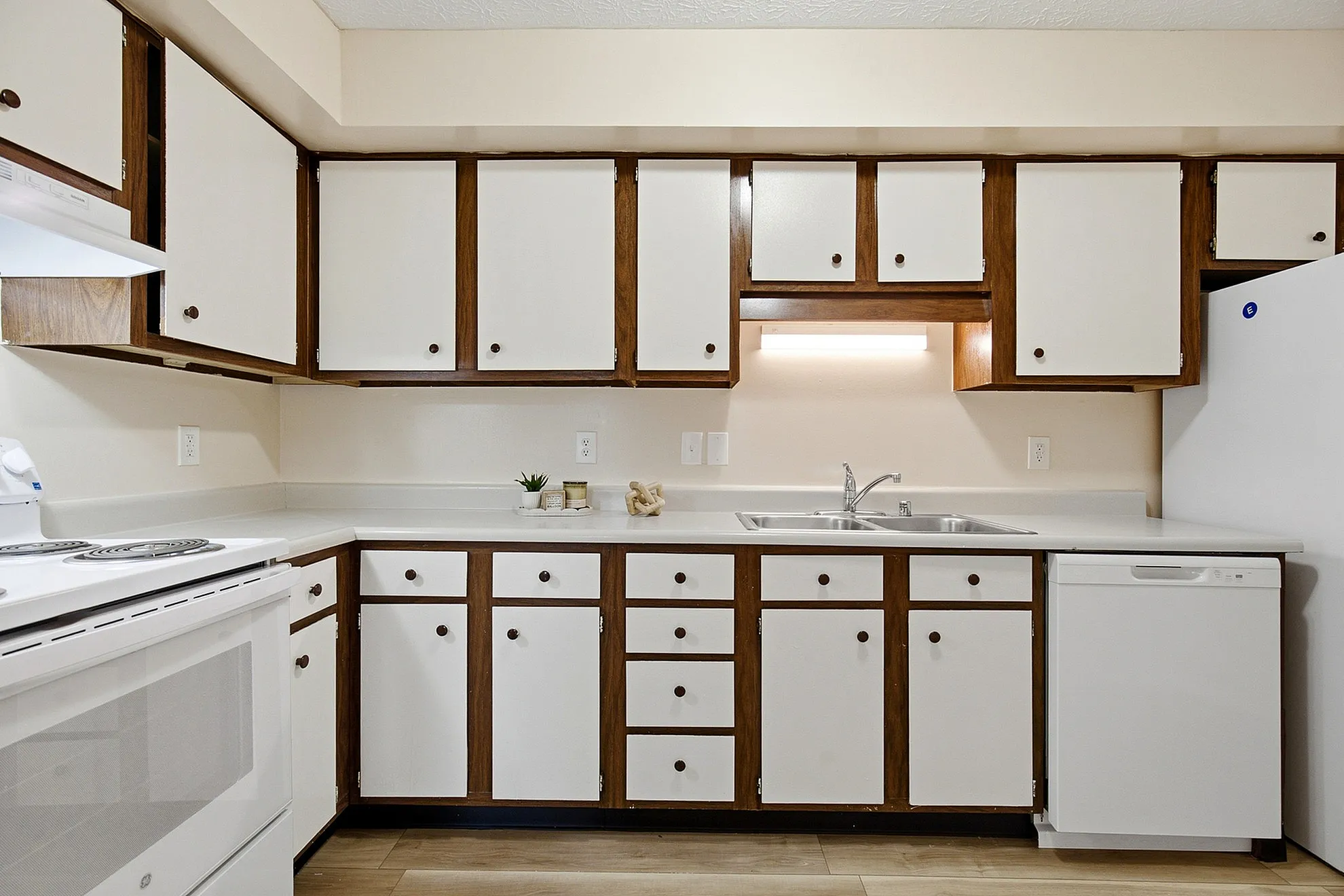 Charming kitchen showcase featuring elegant white cabinetry with wood accents, modern appliances, and sleek countertop space.