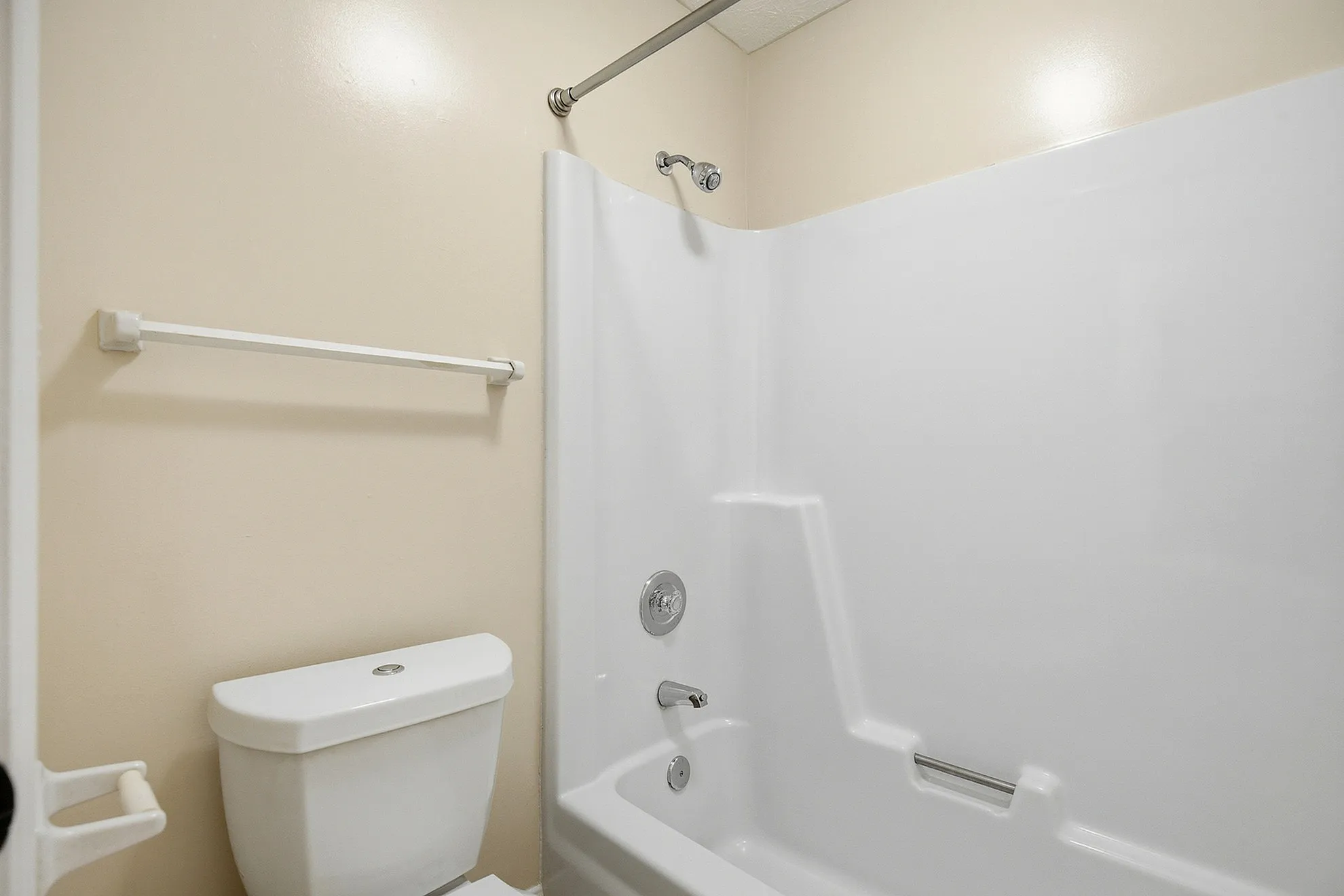 Pristine, modern bathroom featuring a sleek white bathtub and contemporary toilet design.