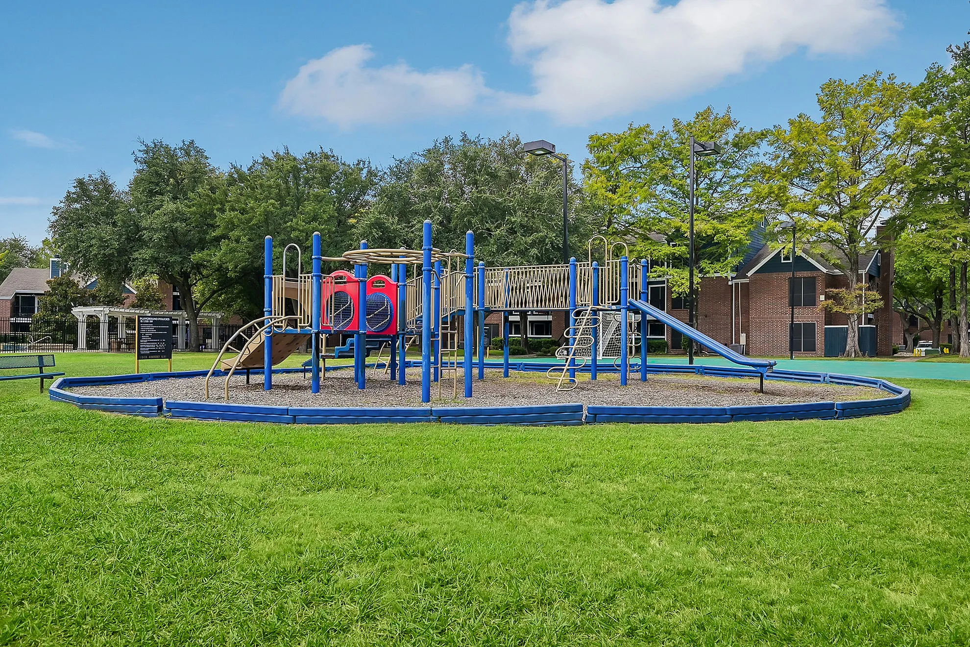 Inviting playground with vibrant slides and climbing structures nestled in a lush green park, ideal for family fun and relaxation.
