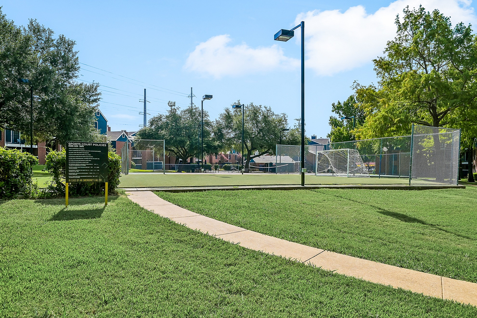 Inviting outdoor sports court surrounded by lush greenery and clear blue skies, perfect for recreational activities.