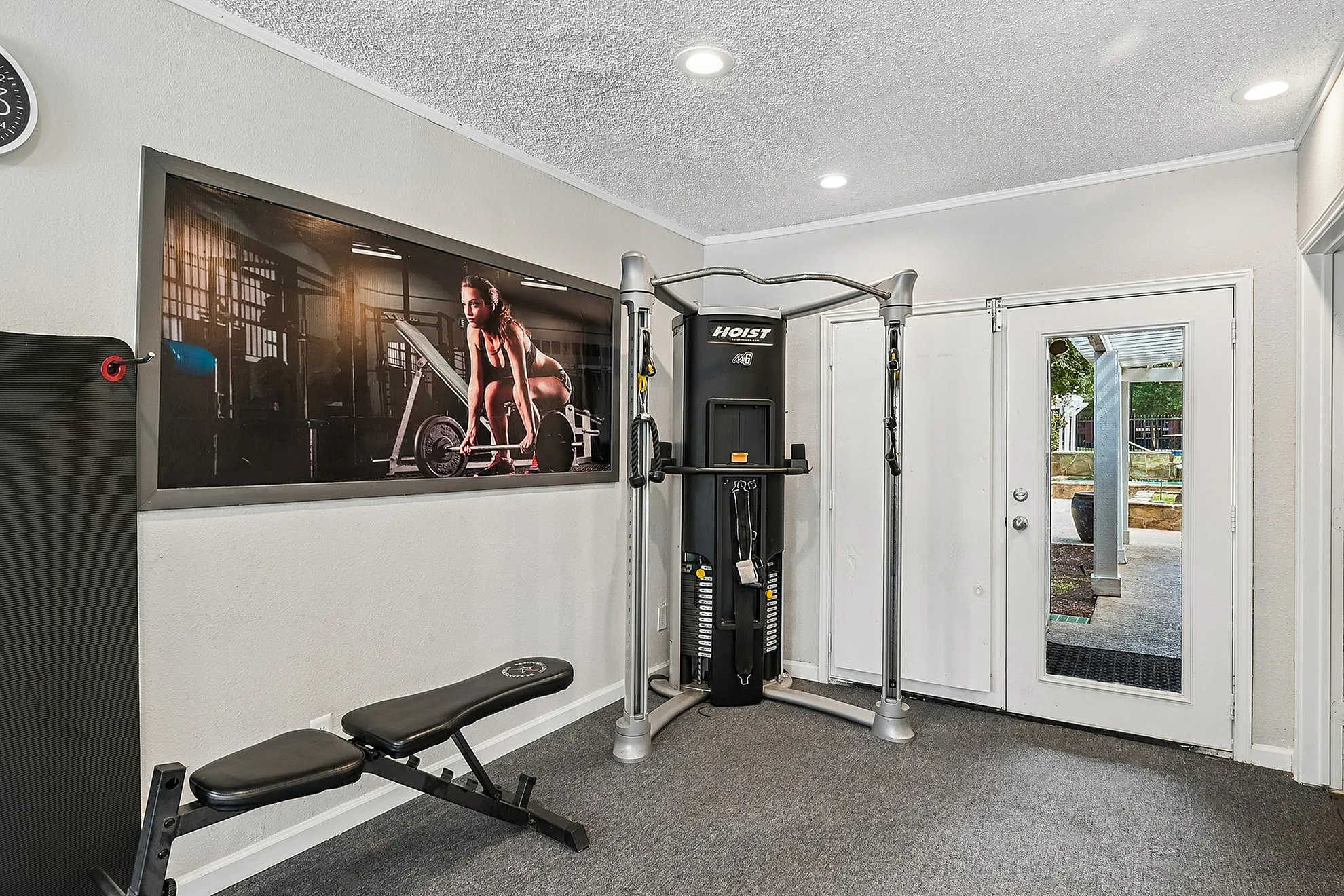 Modern home gym with high-quality fitness equipment, inspiring gym wall art, and elegant outdoor access.