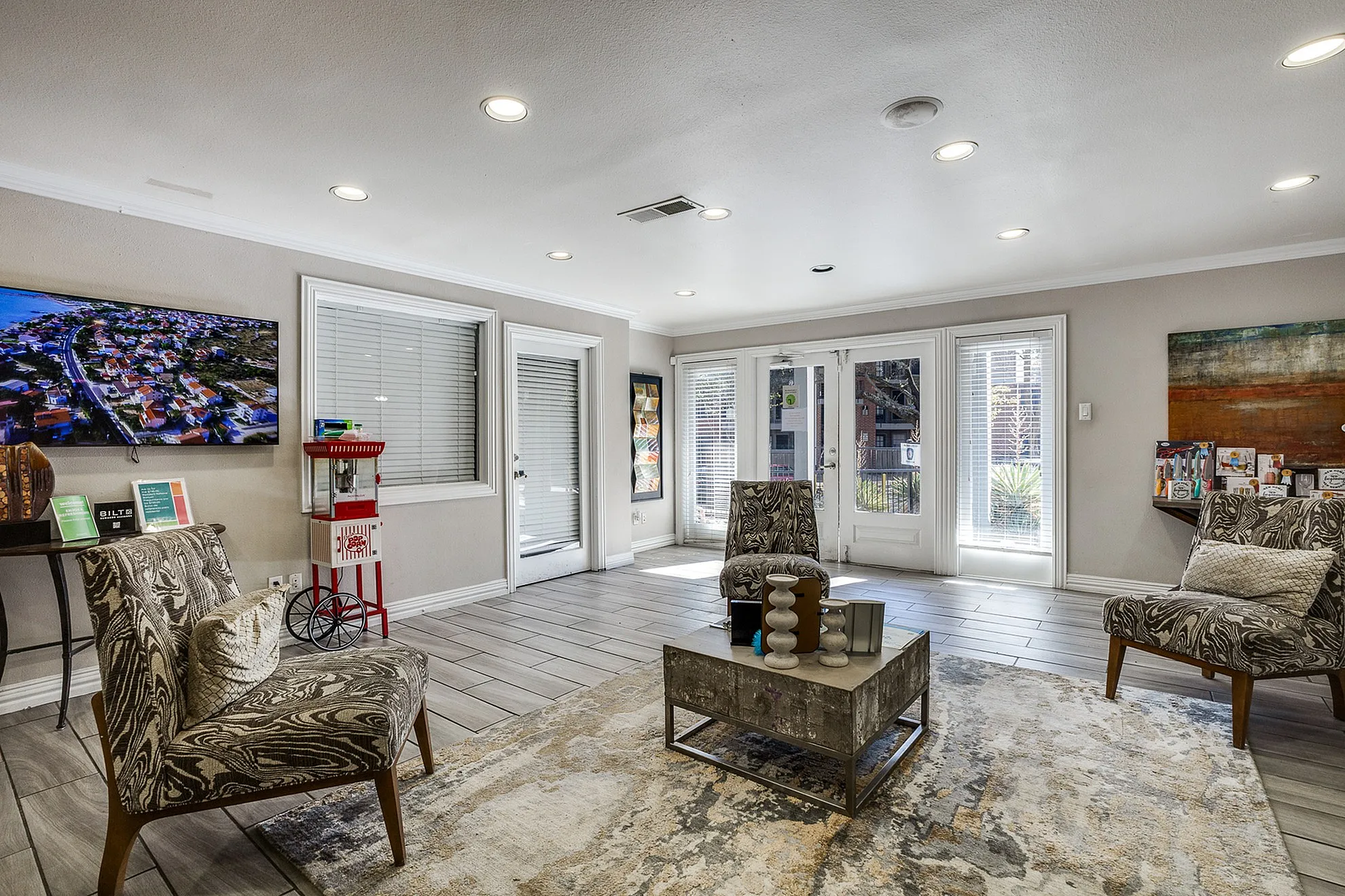Modern living room with elegant decor, featuring stylish chairs, a chic coffee table, and abundant natural light streaming through large windows.