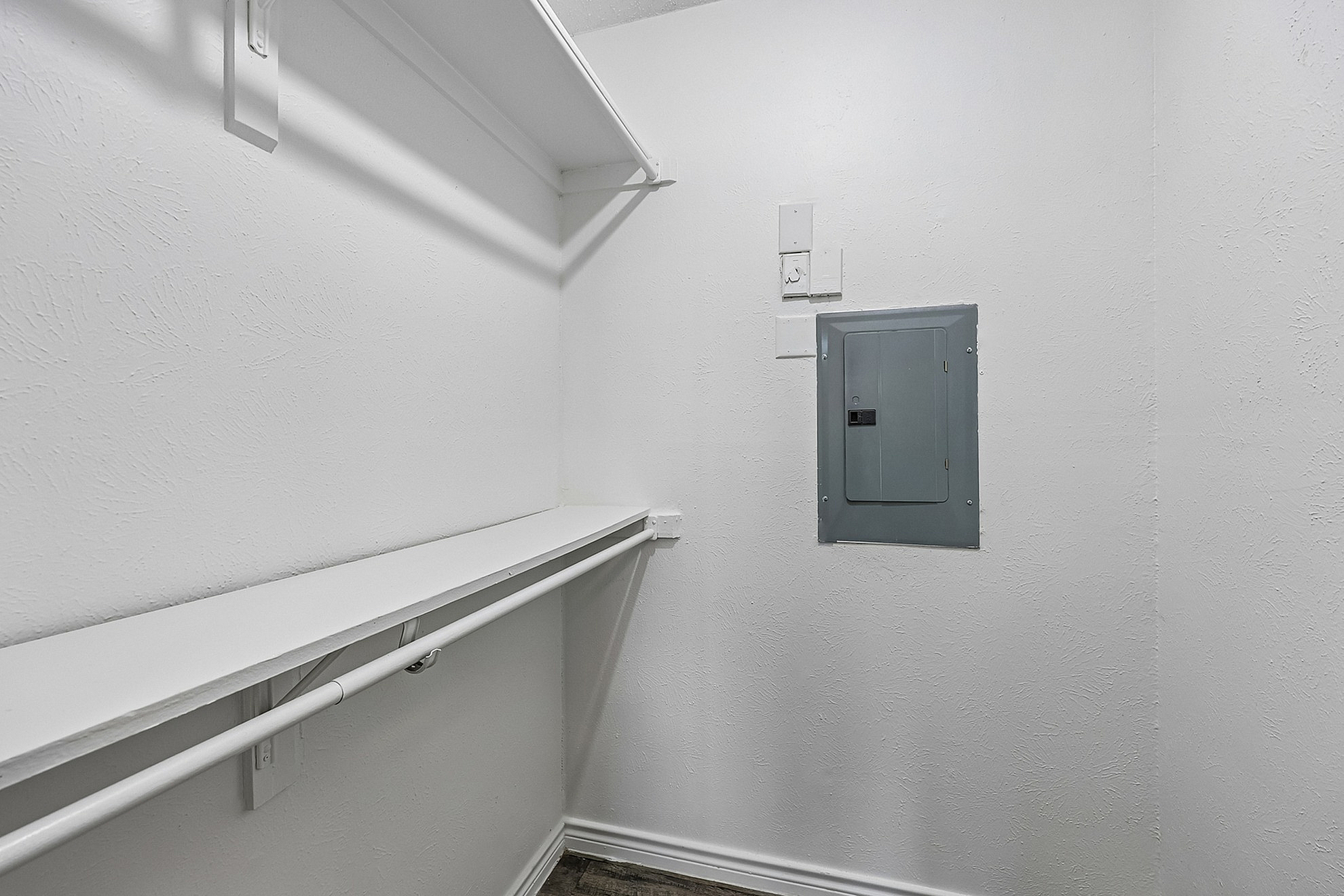 Bright and spacious utility room featuring white textured walls and ample shelving for convenient storage solutions.