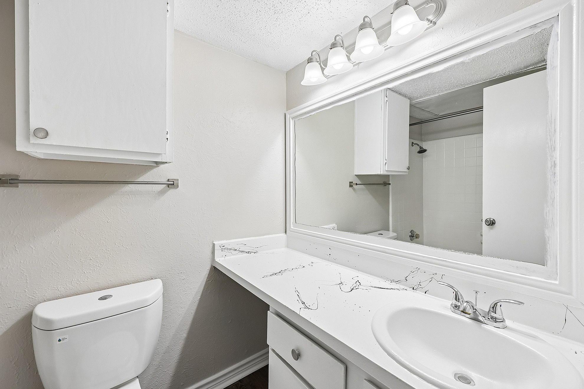 Bright and modern bathroom featuring elegant lighting, sleek white cabinetry, and a polished sink, ideal for stylish living.
