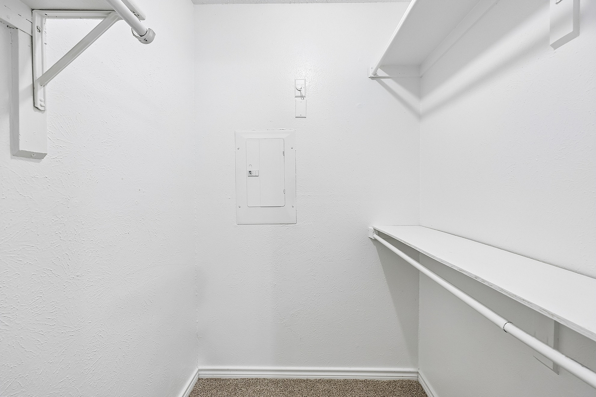 Bright and spacious walk-in closet with ample shelving and hanging space, perfect for organized living.