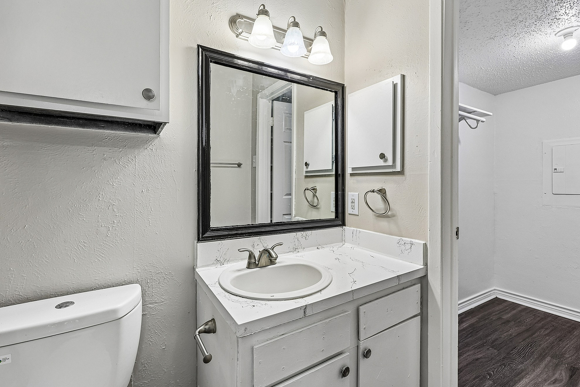 Modern bathroom with chic white vanity, elegant mirror, and ambient lighting for a serene retreat.