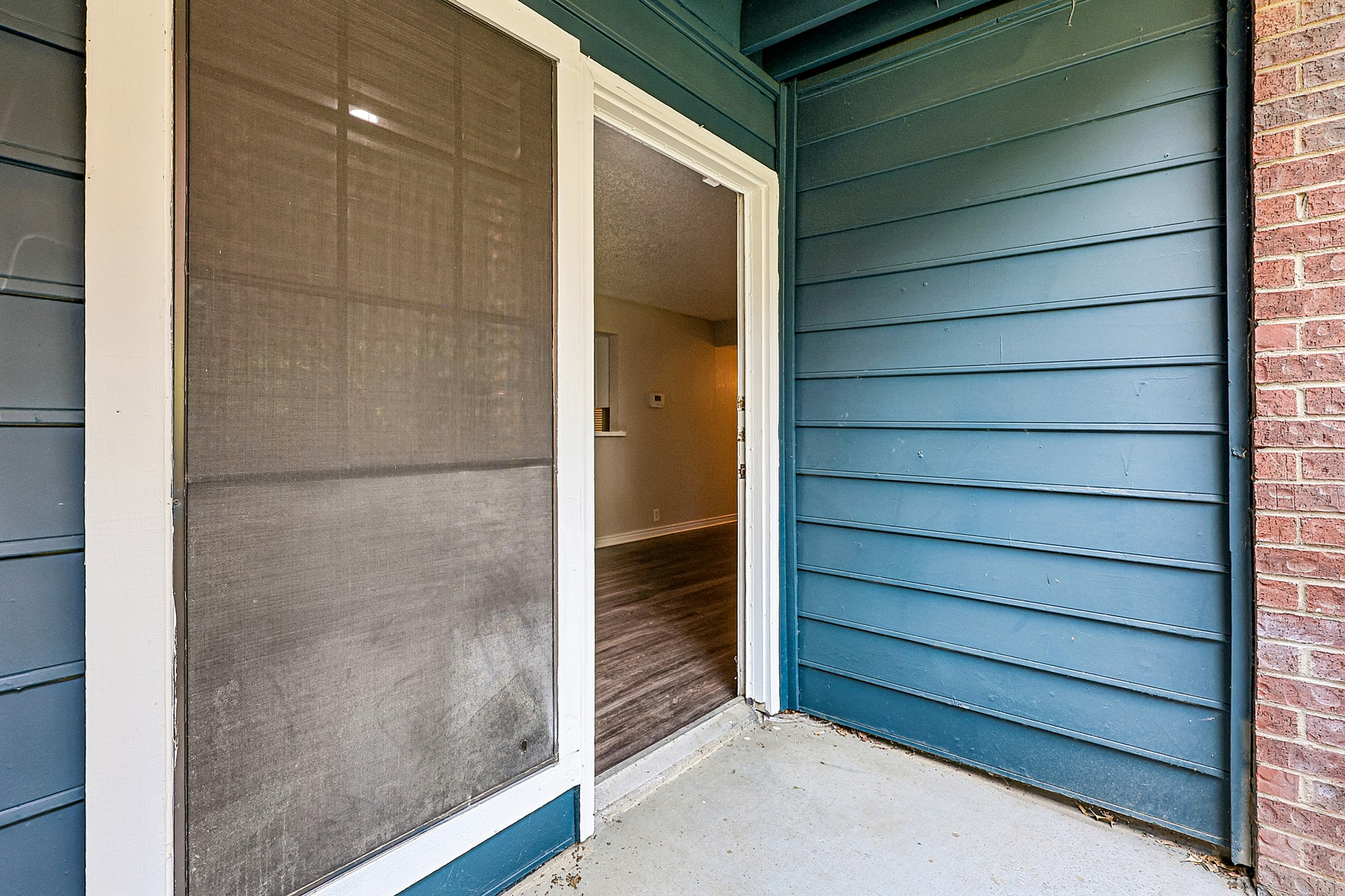 Inviting entrance with sleek glass door and contemporary blue siding, leading to a modern interior.