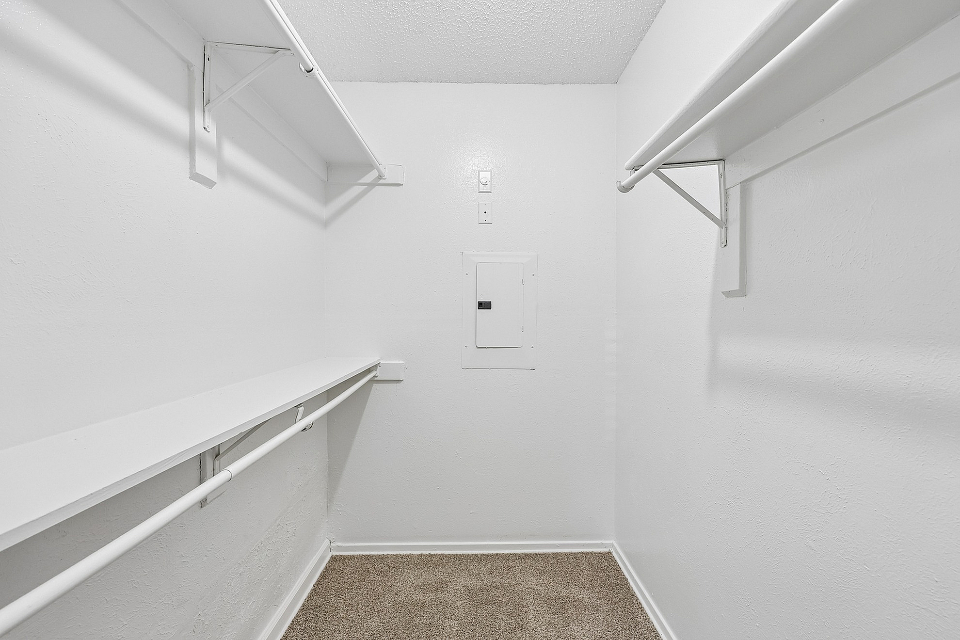 Spacious walk-in closet with white shelving and ample storage space, perfect for organizing a stylish wardrobe.