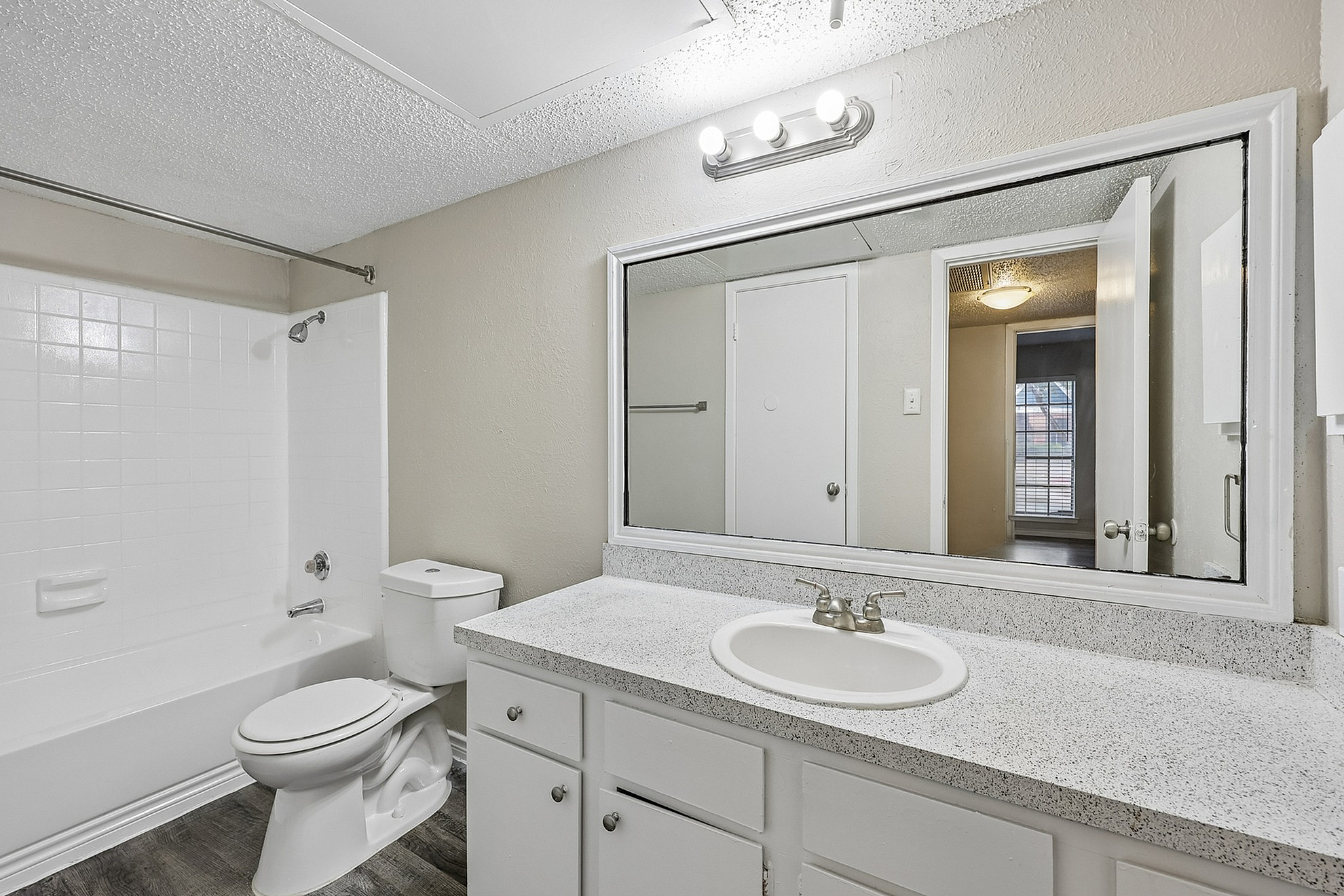Chic and modern bathroom with sleek granite countertop, large mirror, and stylish fixtures.
