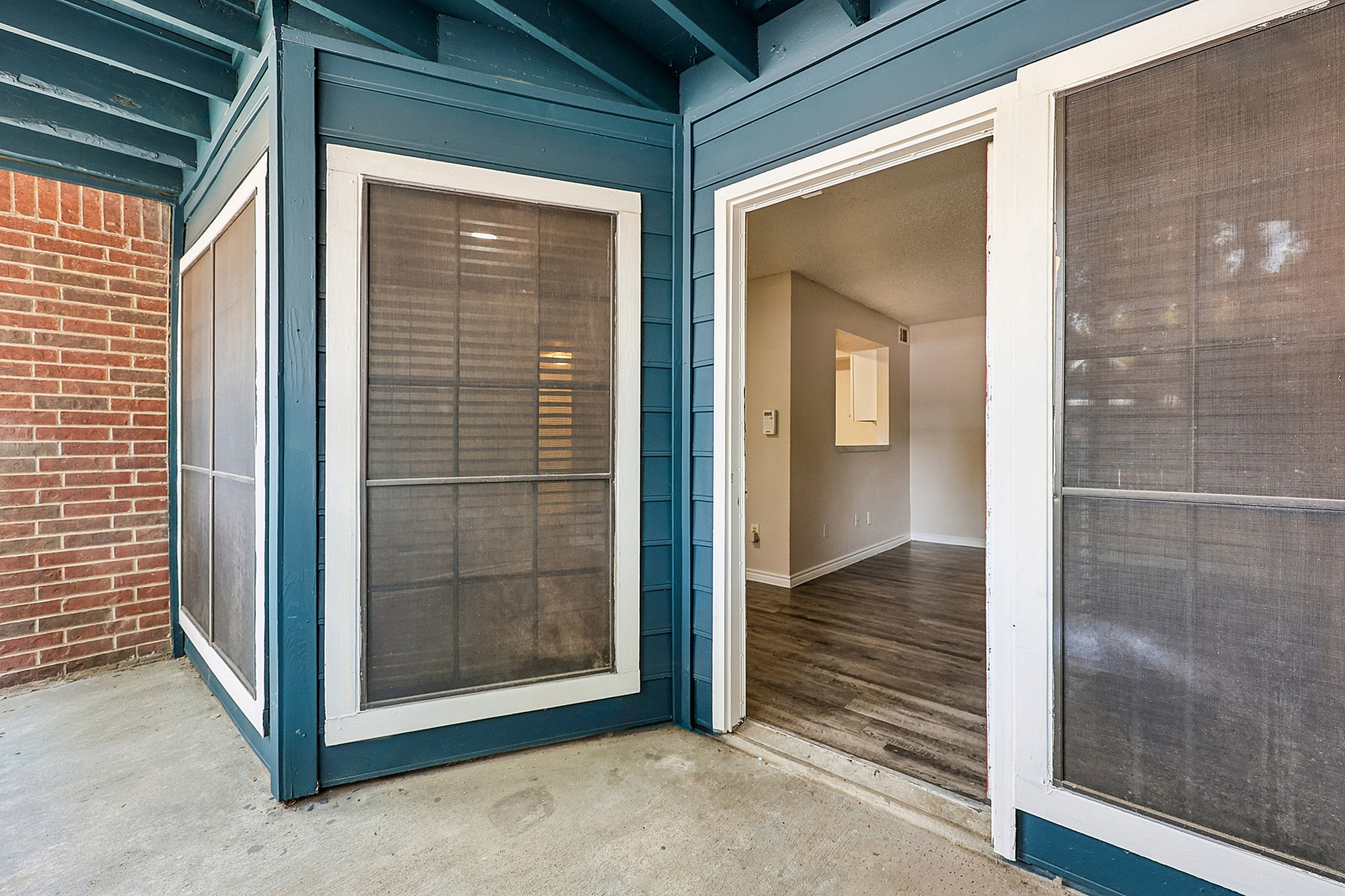 Charming apartment entryway with large windows, featuring stylish wood flooring and inviting open-concept design.