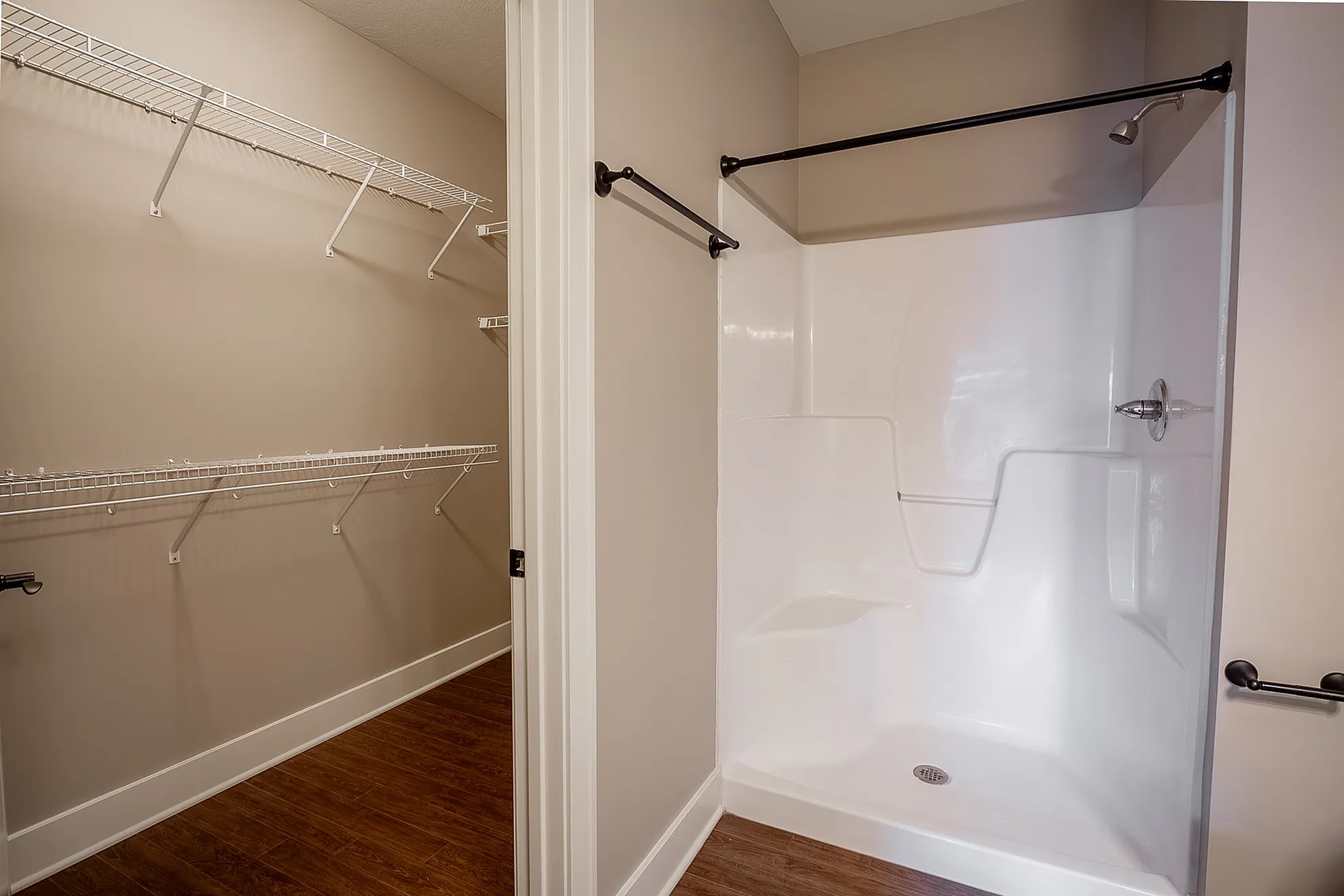 Modern bathroom with elegant white shower and spacious walk-in closet featuring ample built-in shelving.