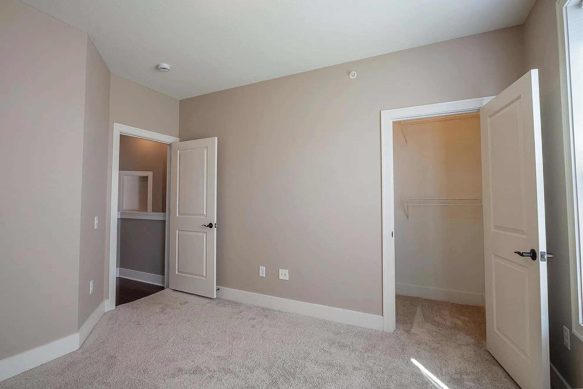Inviting bedroom boasting plush carpet, neutral walls, and ample closet space for comfortable living.