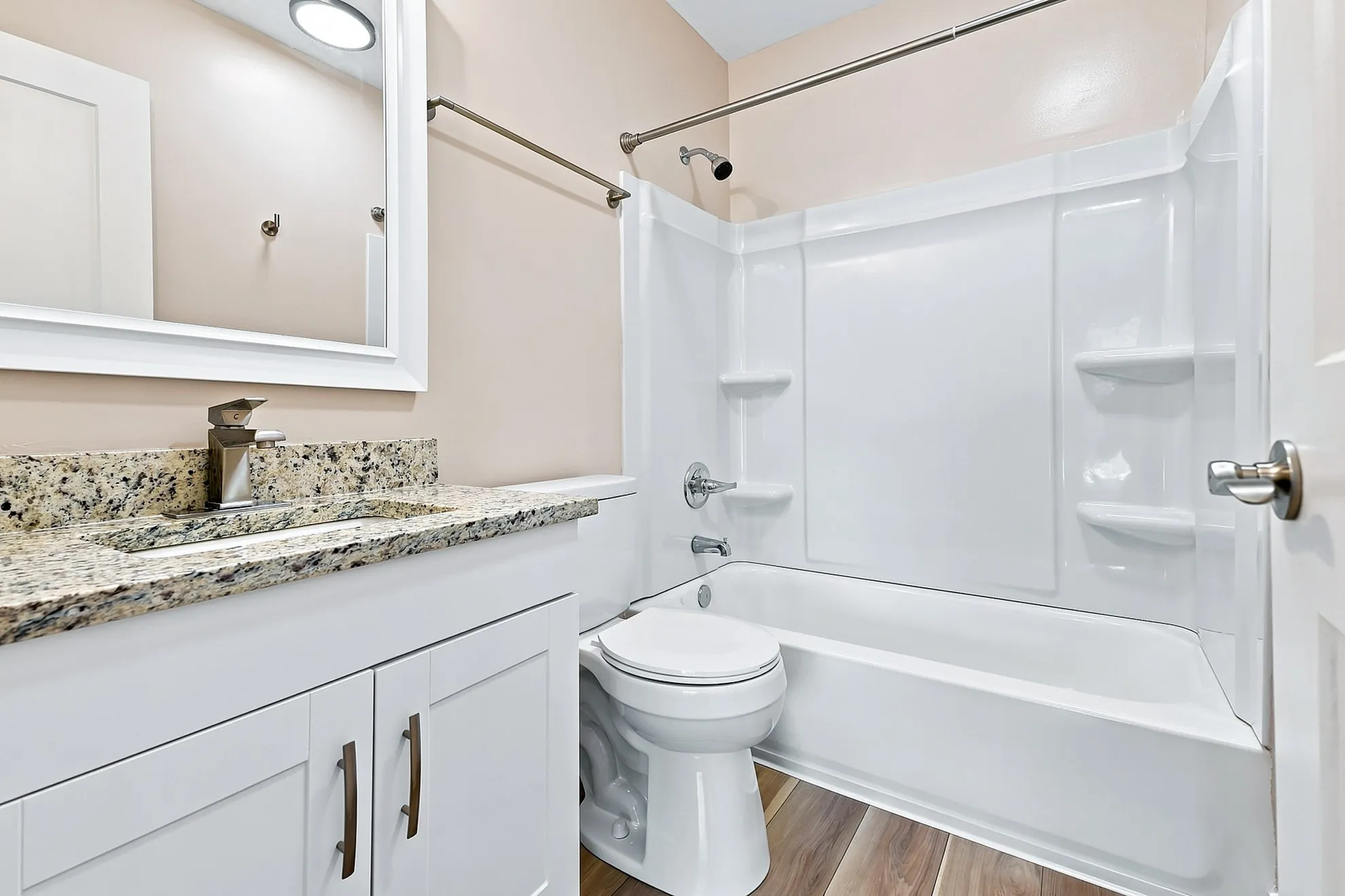 Elegant bathroom with granite vanity, modern fixtures, and a pristine bathtub enhancing a serene atmosphere.